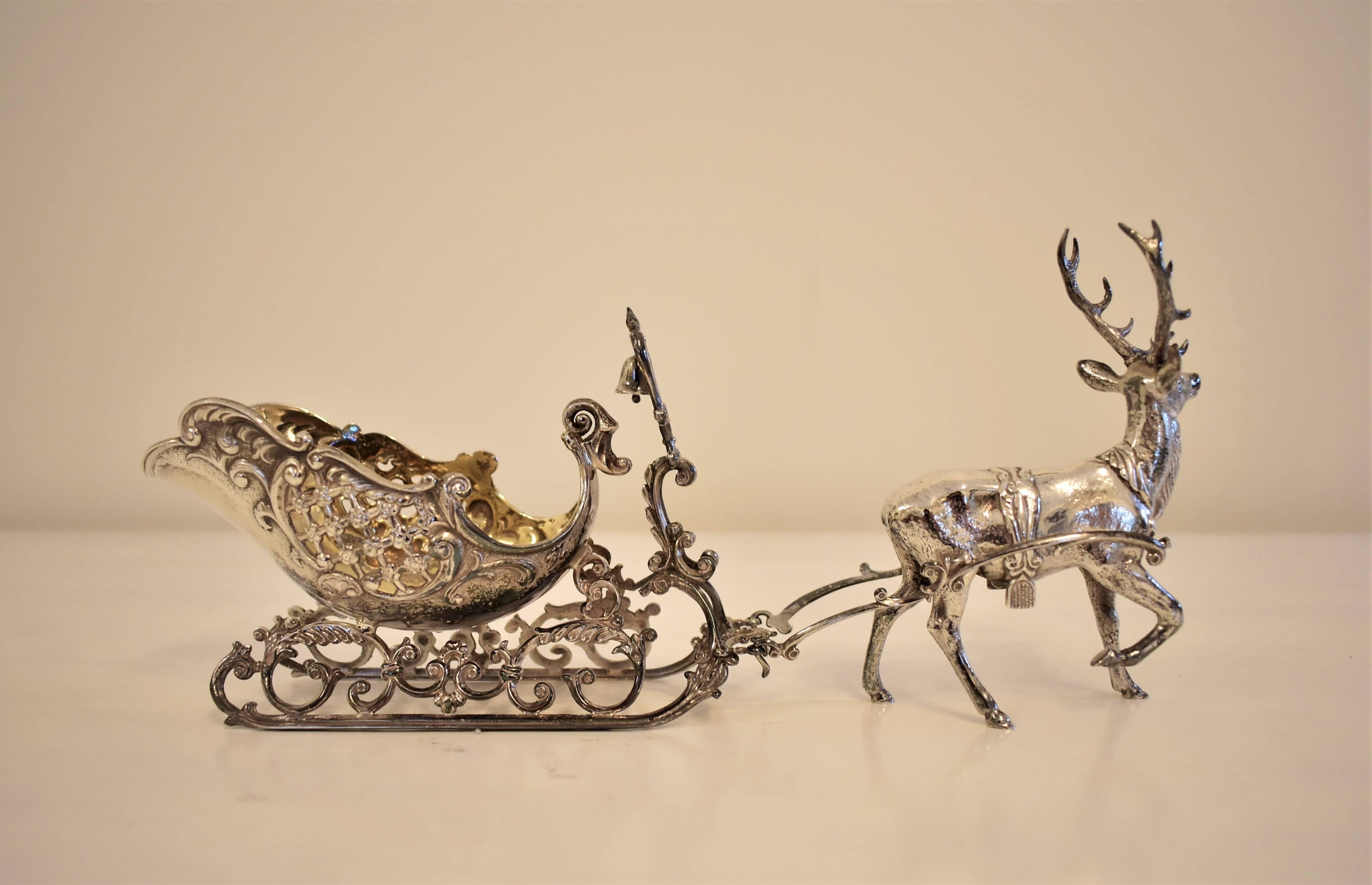 A delicate detailed silver sledge or sleigh complete with functioning bell drawn by a reindeer in walking pose. The interior of the sleigh is gilded. Intricately detailed and ornate with finely hand chased finishings to give very realistic feel.