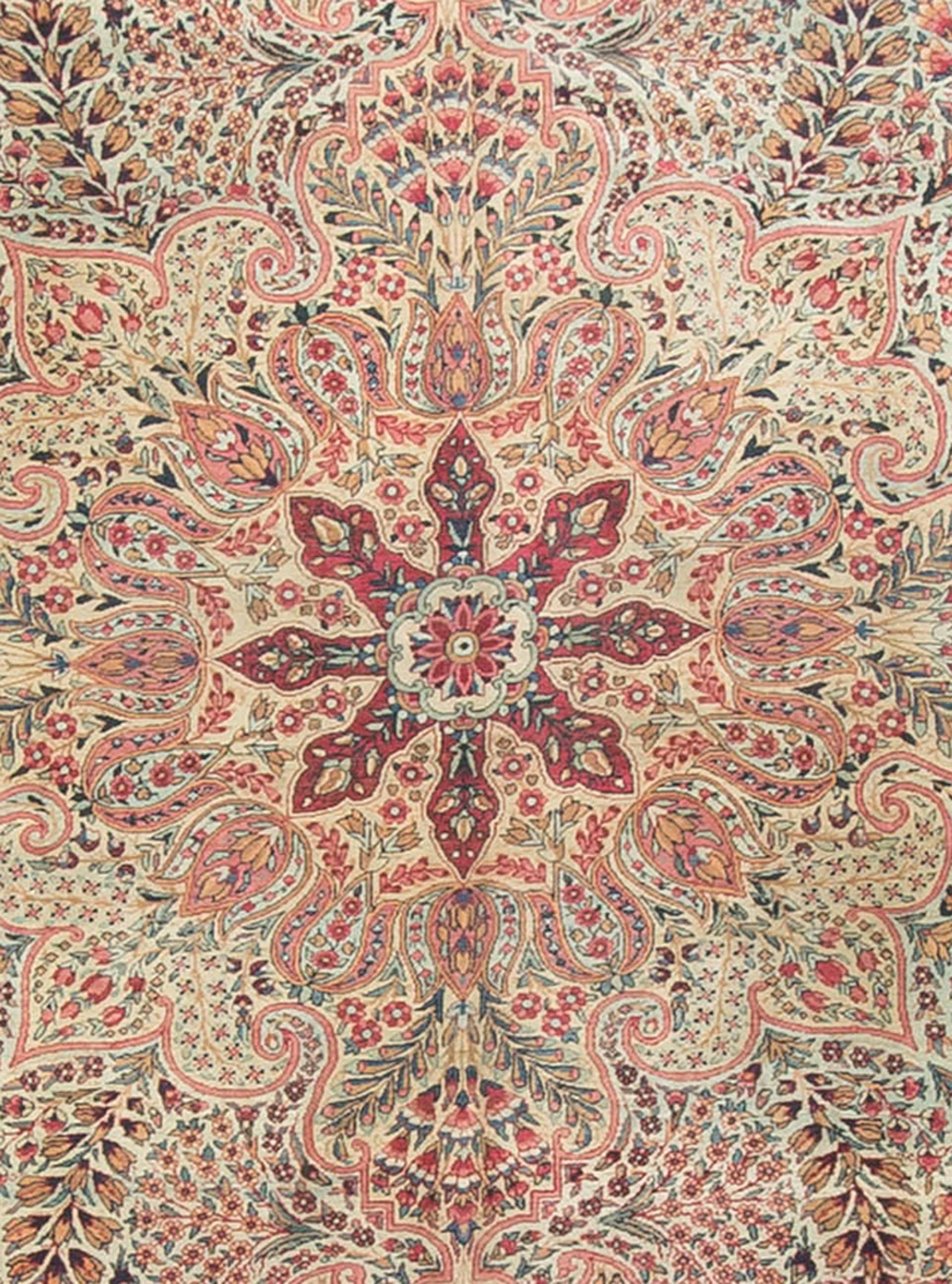 An antique Persian Kerman rug, circa 1900. The wonderful field design of intricate floral patterns creates an impression that it is swirling out from the centre medallion with the corner spandrels in the same style anchoring the design into place.