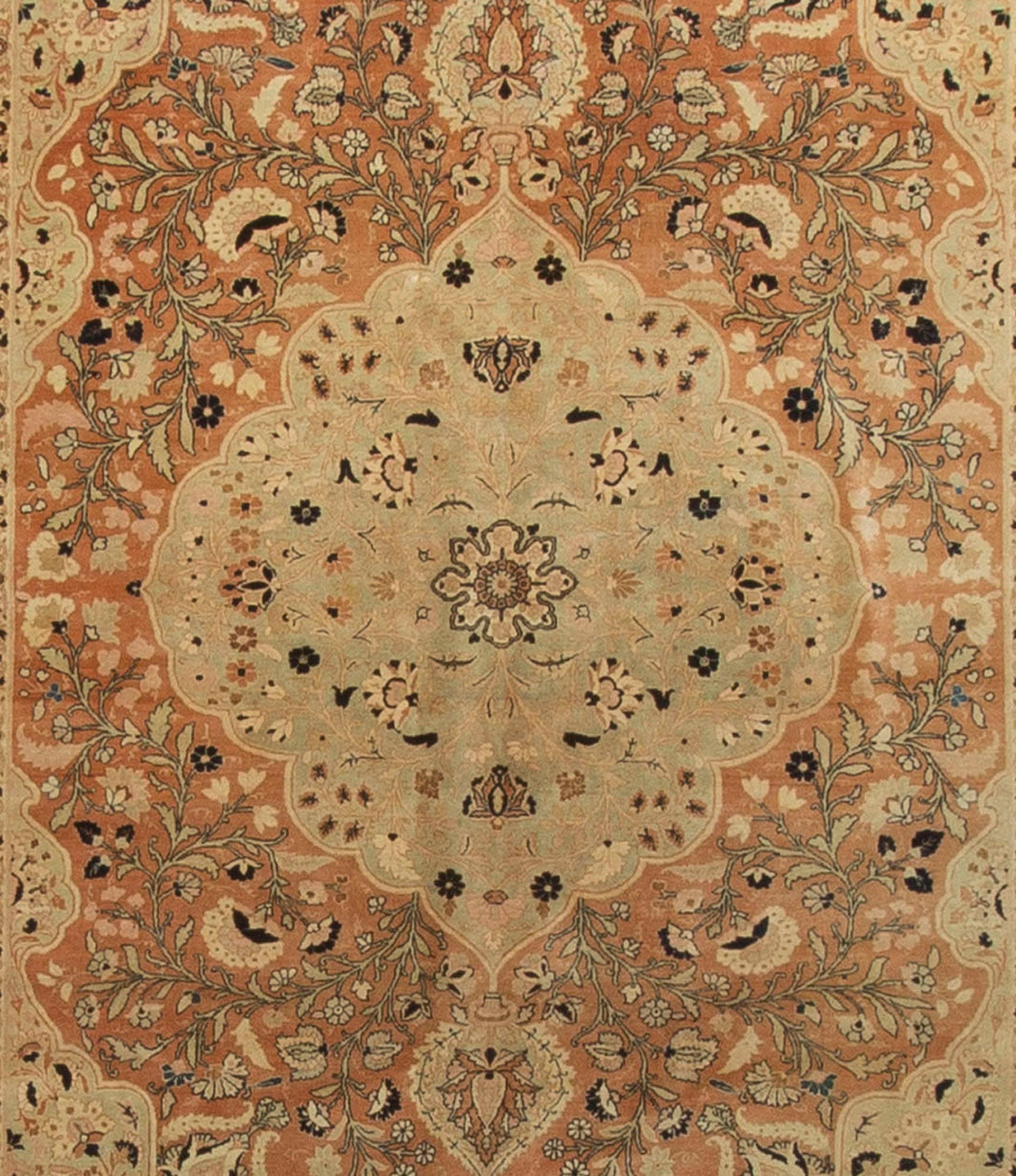 A lovely light and open antique Tabriz with a soft central pattern encompassed by a deeper rust colored surround. A dark blue main border that emphasizes the quietness of the principal design combined with four soft guard borders frames the rug to