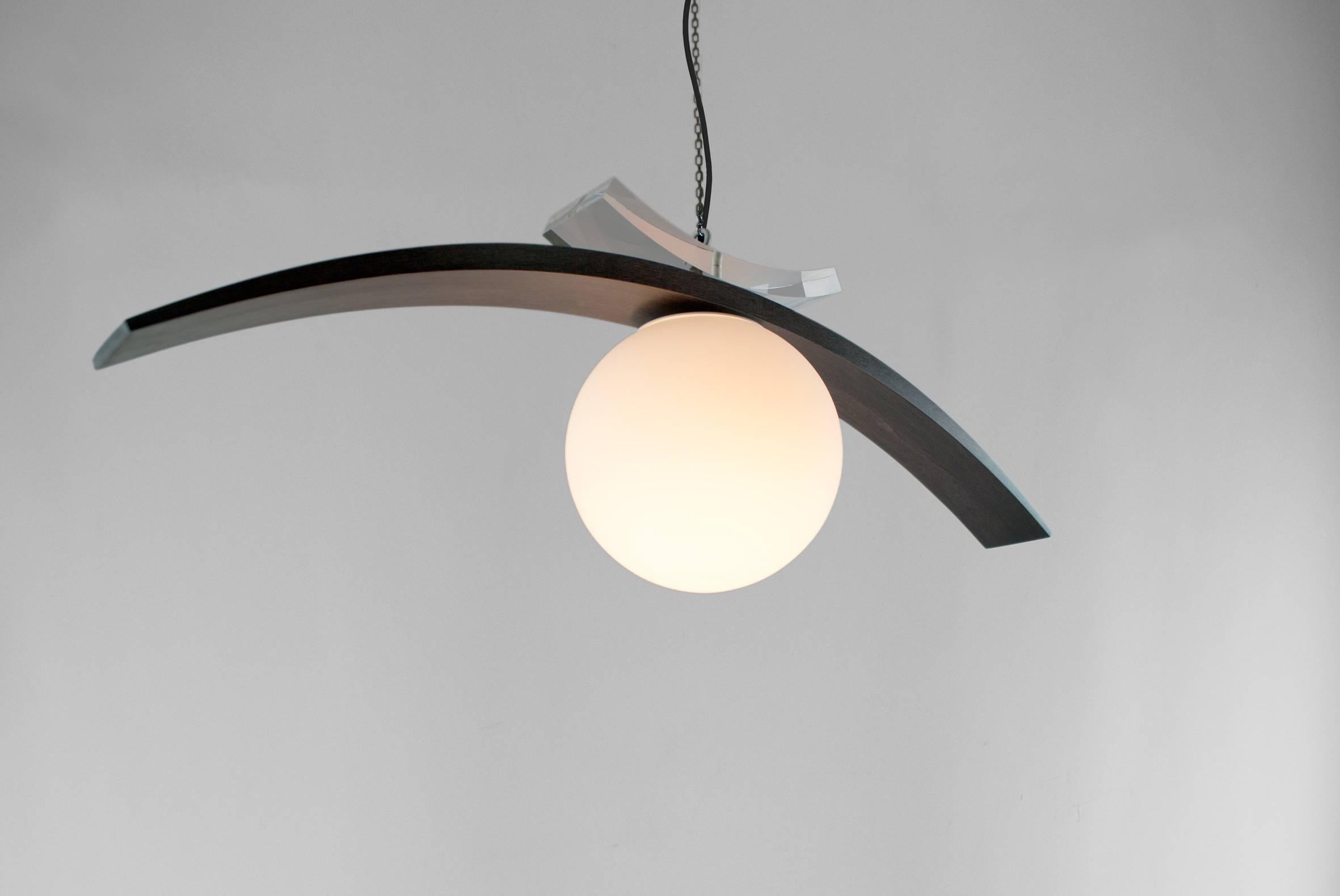 Louis Jobst' Eye Pendant is the abstracted form of an eye, hanging free in space. It is surreal yet contemporary creating an elegant and iconic design. The tapering maple eye lid provides many different shapes and forms due to its profile. The