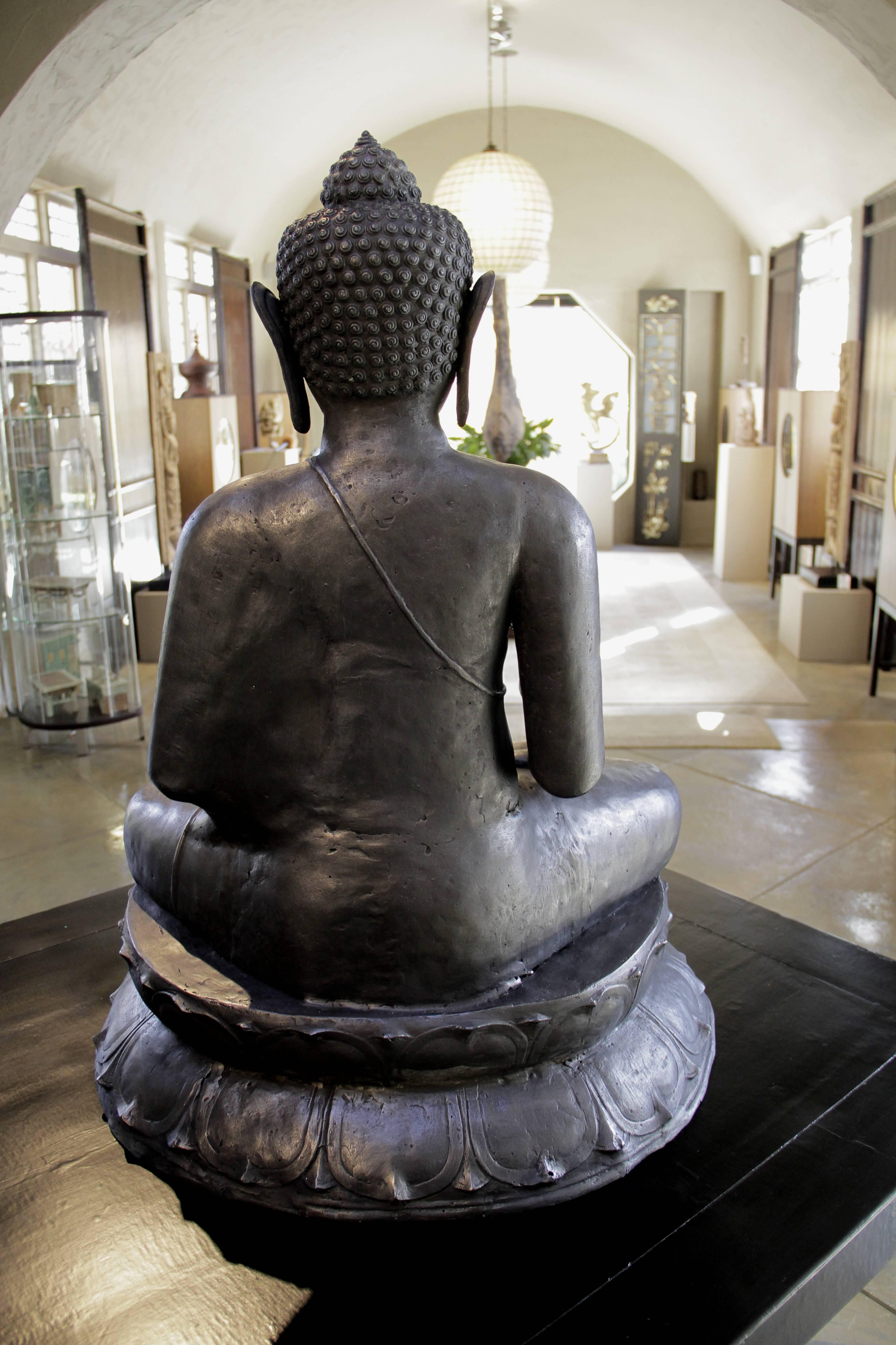 Large copper seated Buddha from Java

In the style of a Javanese Esoteric Buddha of the 7th-15th century, this Classic Buddha is seated on a large double-lotus pedestal in the cross-legged meditative posture of vajraparyankasana with the right leg