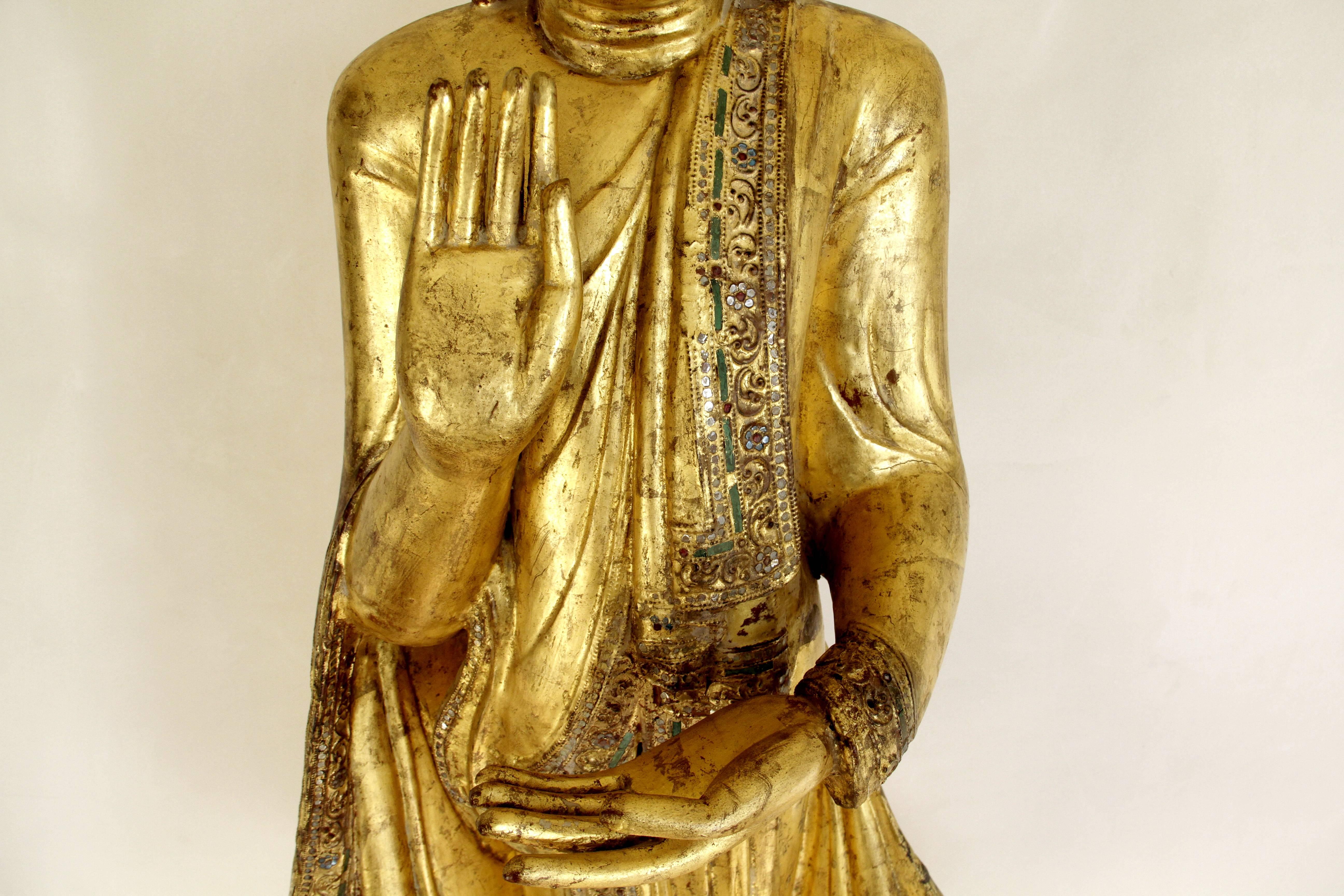 This wooden standing Buddha is covered in gold. He is from Burma in the late 19th Century from the Mandalay period. He comes with a certificate of description and evaluation. He stands 64 inches tall and is in excellent condition. He stands on a