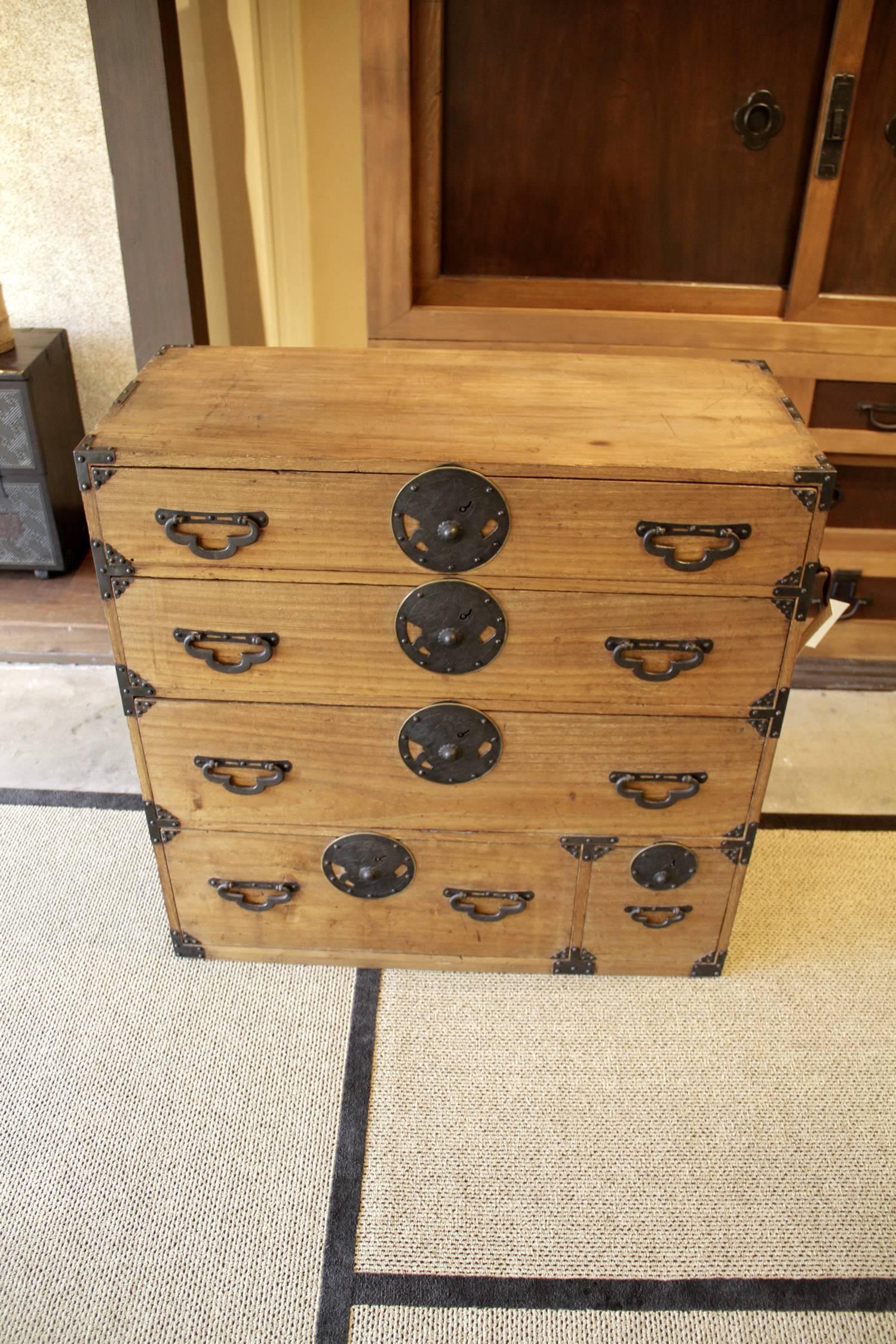 This Japanese Tansu chest has round iron hardware that is from the 19th century, circa
1890s-1900s. It is a one section tansu made of Paulownia or Kiri wood. This clothing chest or “Tansu” in Japanese a crane image carved into the metal