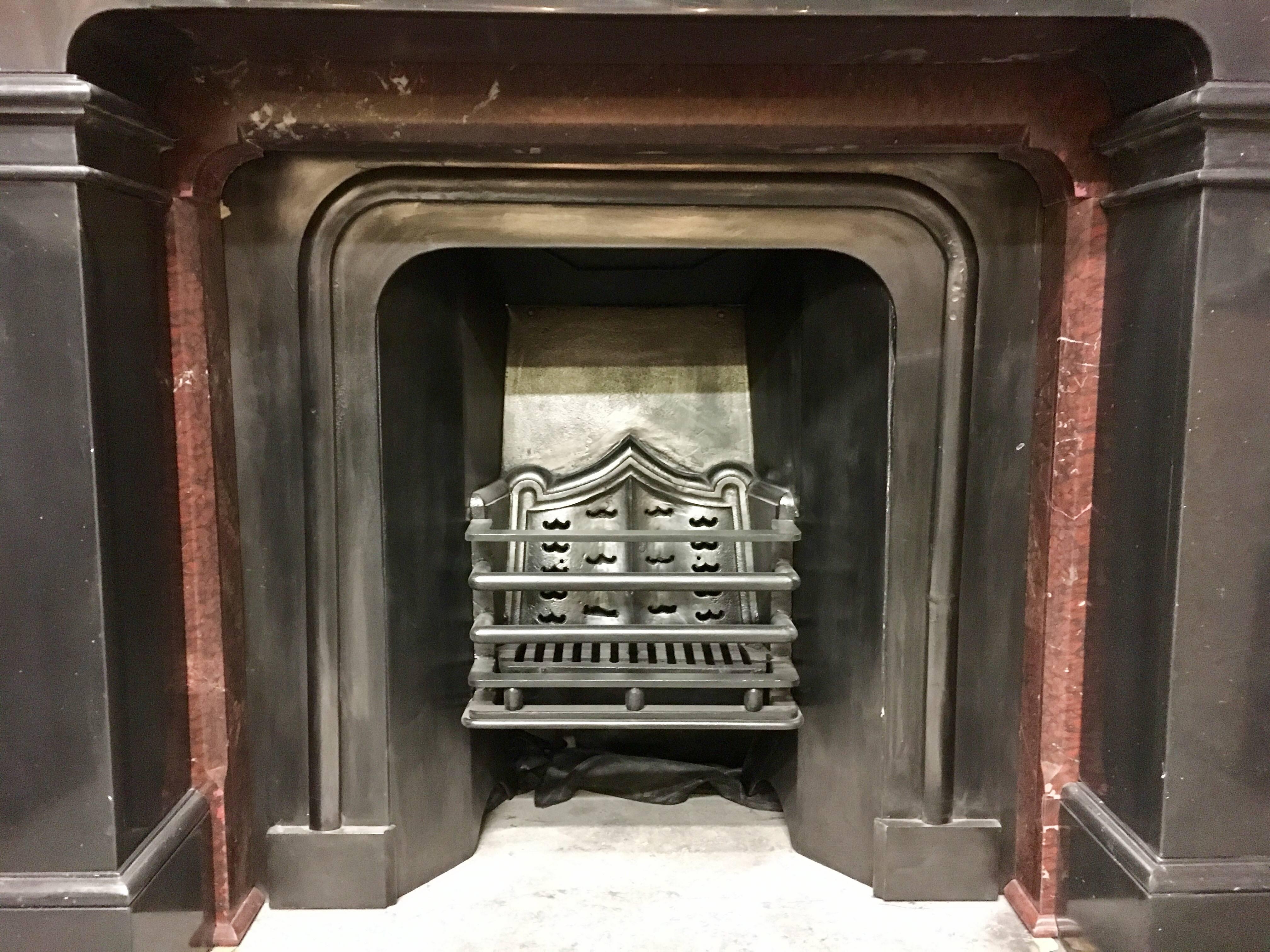 A large and masculine 19th Century Victorian Belgian black marble fireplace, Scottish in origin, this piece has been fully restored and polished. Shown with its original cast iron insert and red Griotte marble internal slips.