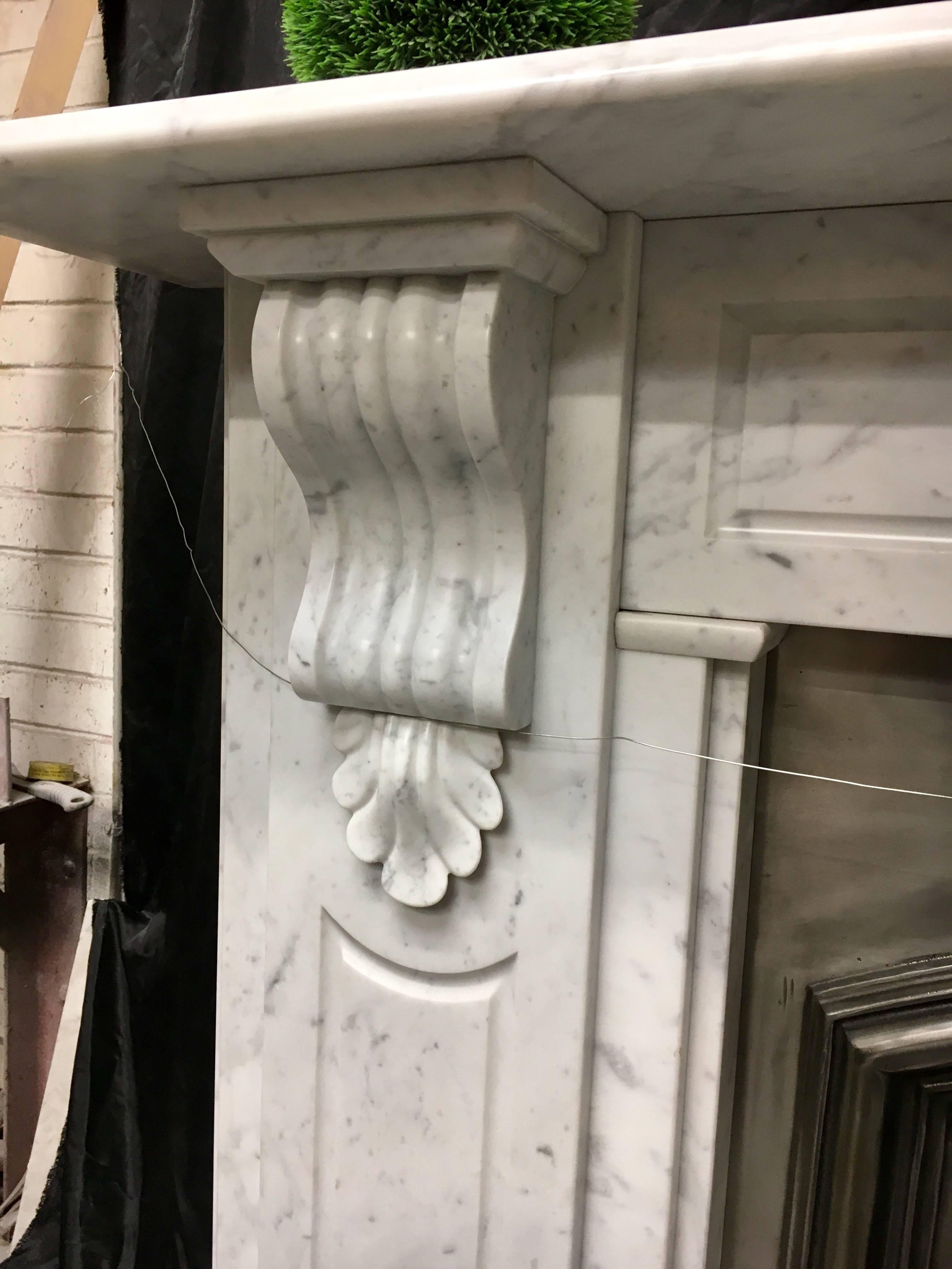 A large Victorian style Carrara marble corbel fireplace with recessed panels to jambs and frieze, nice proportions and color will suit a wood burning stove or cast insert. Fully restored and ready to install.