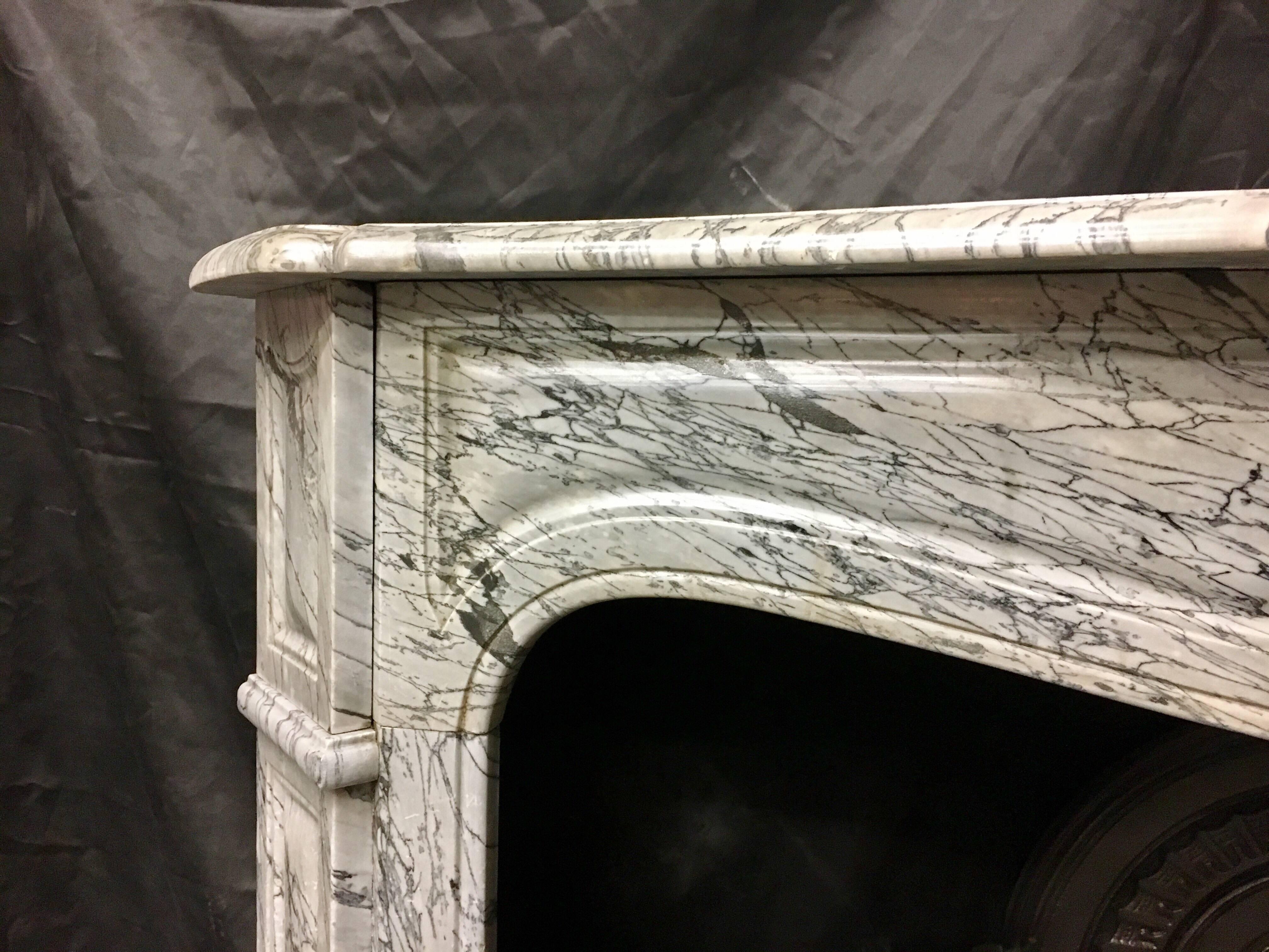 A pretty and petite antique Pompadour French Louis XVI style Bleu Fleuri marble fireplace, with cushion panels. 
French, early 19th century. 

Fire opening size: 850mm wide x 865mm high (inside sizes).