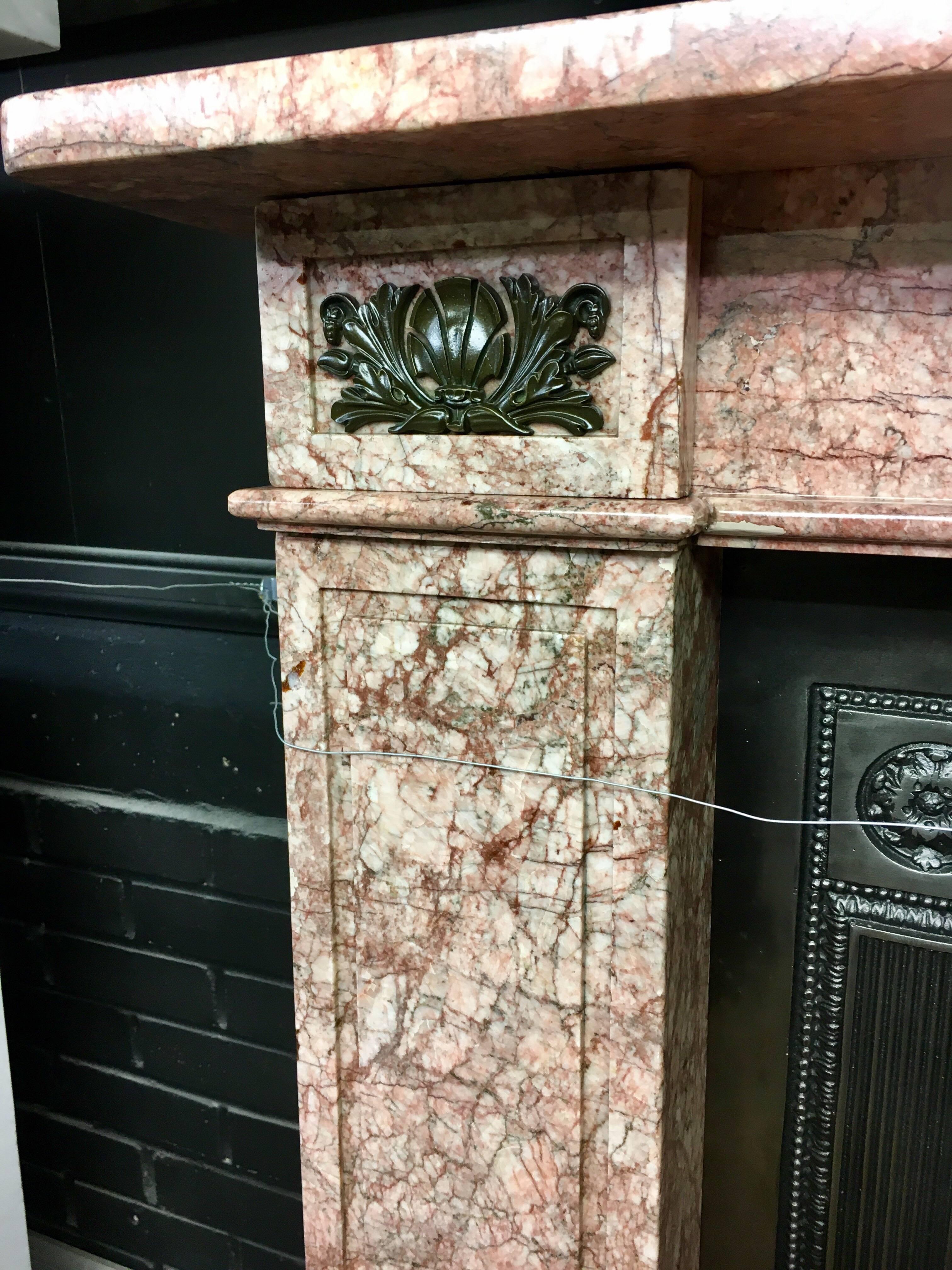A fine and attractive antique French Empire, early 19th century fireplace mantel surround in richly variegated Rosso De Valencia marble, a square top sits above an unadorned frieze flanked by Bronze shell cartouche paterae on the end blocks above