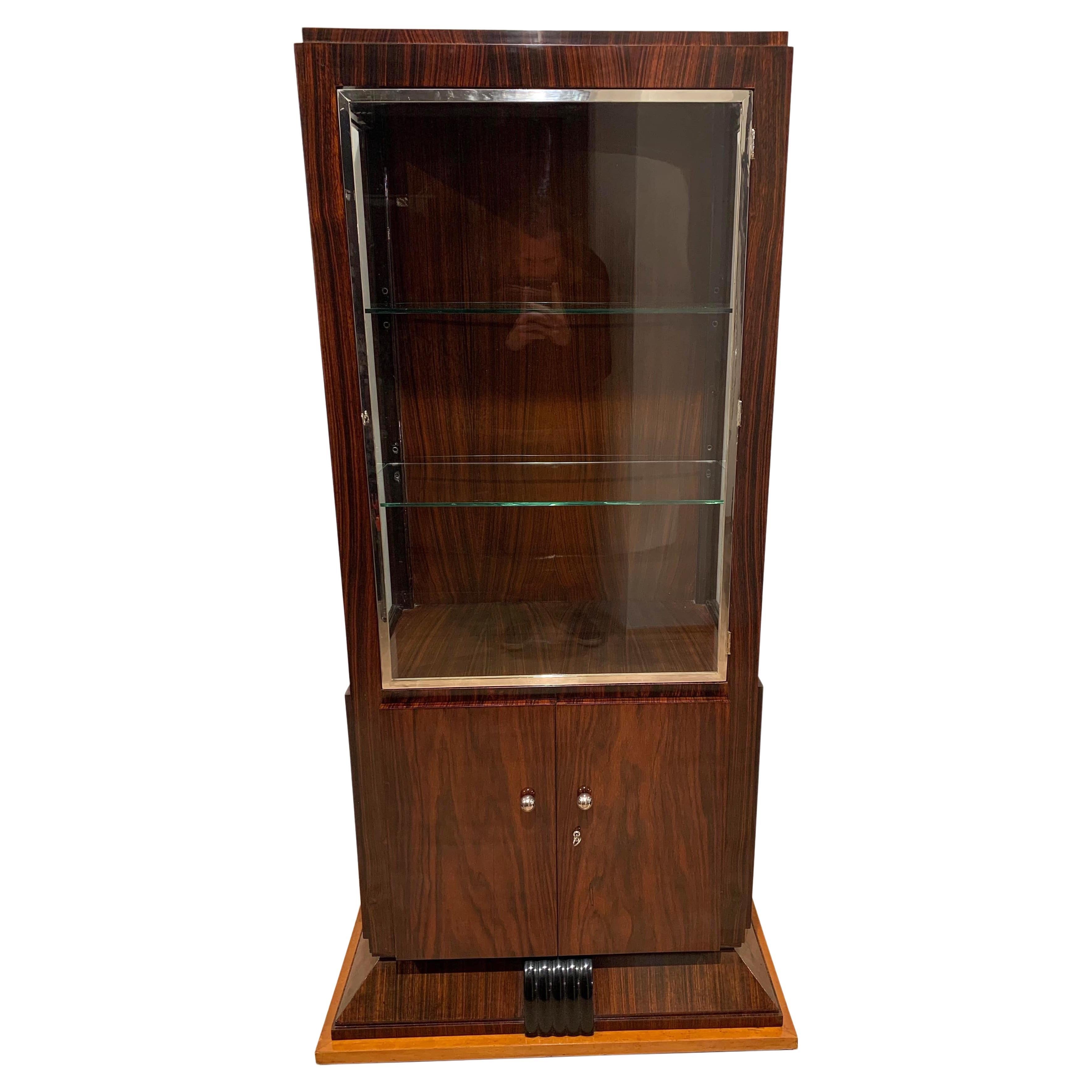 Elegant straight-lined, Art Deco period Vitrine or Showcase with three sides glass from France about 1925.

Rosewood / Palisander veneered on the in- and outside. 
Base in maple solid wood. 
Top with one door and original chromed metal frame. Bottom