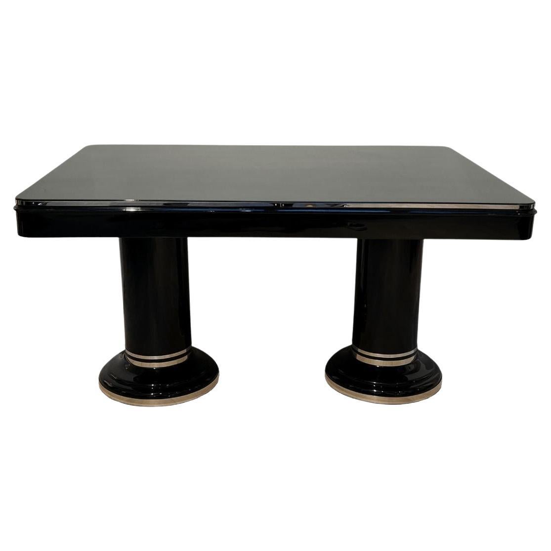 Elevate your dining room with this exquisite French Art Deco extending table, meticulously restored to its full glory. The table features a sleek black piano lacquer finish that exudes elegance, revealing the beautiful mahogany veneer underneath.