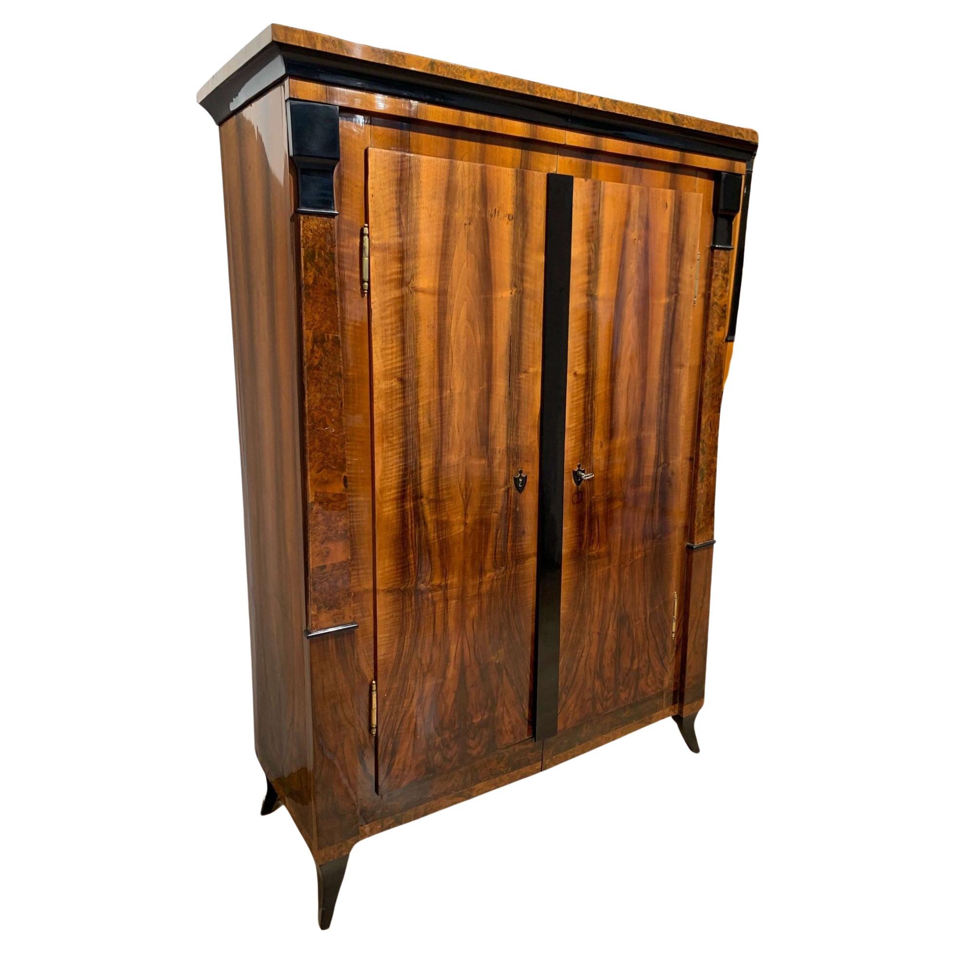 Very elegant two-doored neoclassical Biedermeier armoire from South Germany, circa 1820. Great, balanced design with a beautiful wood composition and ebonized pilaster columns.

The front, sides are veneered in a beautifully grained bookmatched