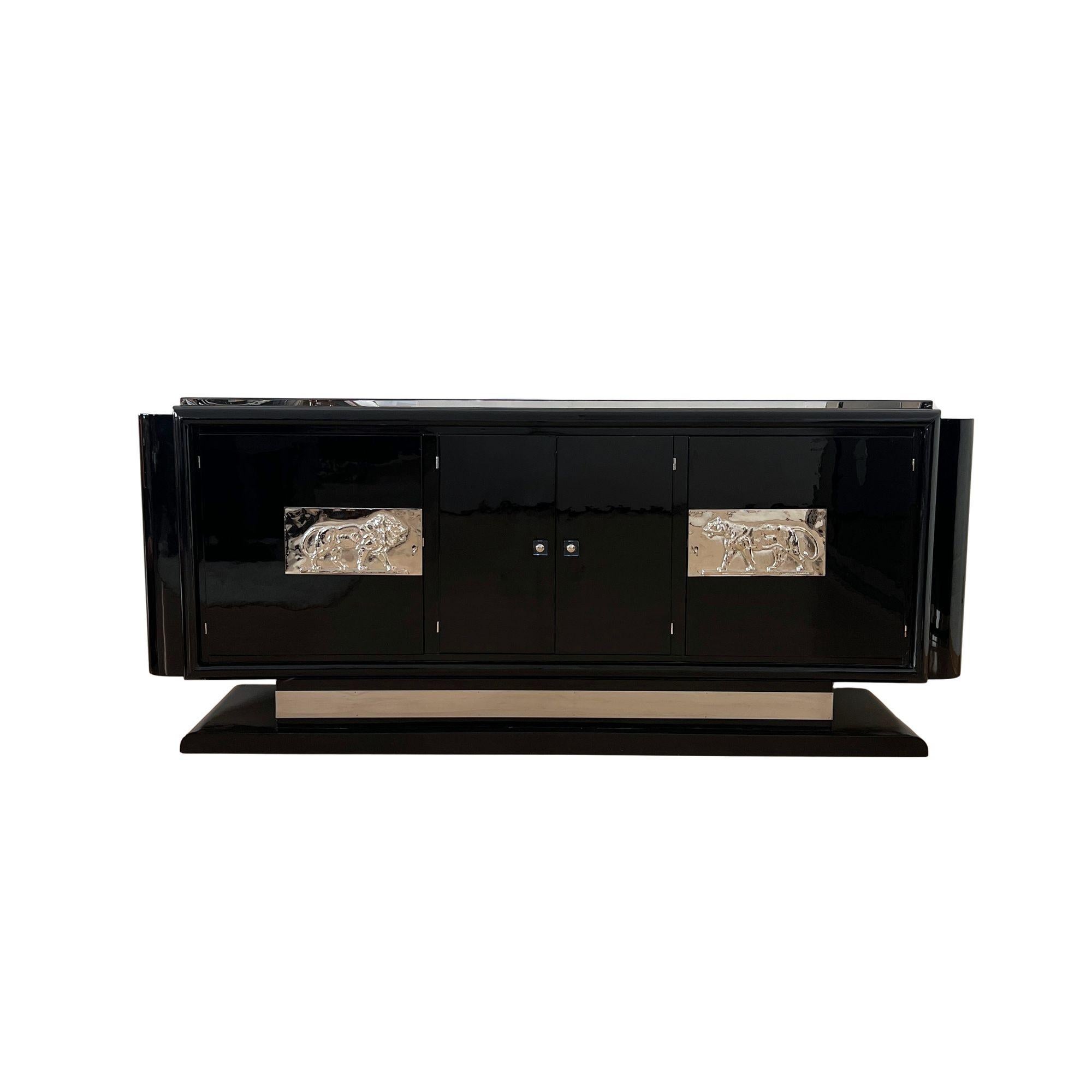 Spectacular original, restored Art Deco Sideboard or Buffet from France around 1930.

Walnut body, black piano lacquer in several layers, high gloss polished. On the doors are two large (36 x 18 cm) cast, chased and chrome-plated appliqués depicting