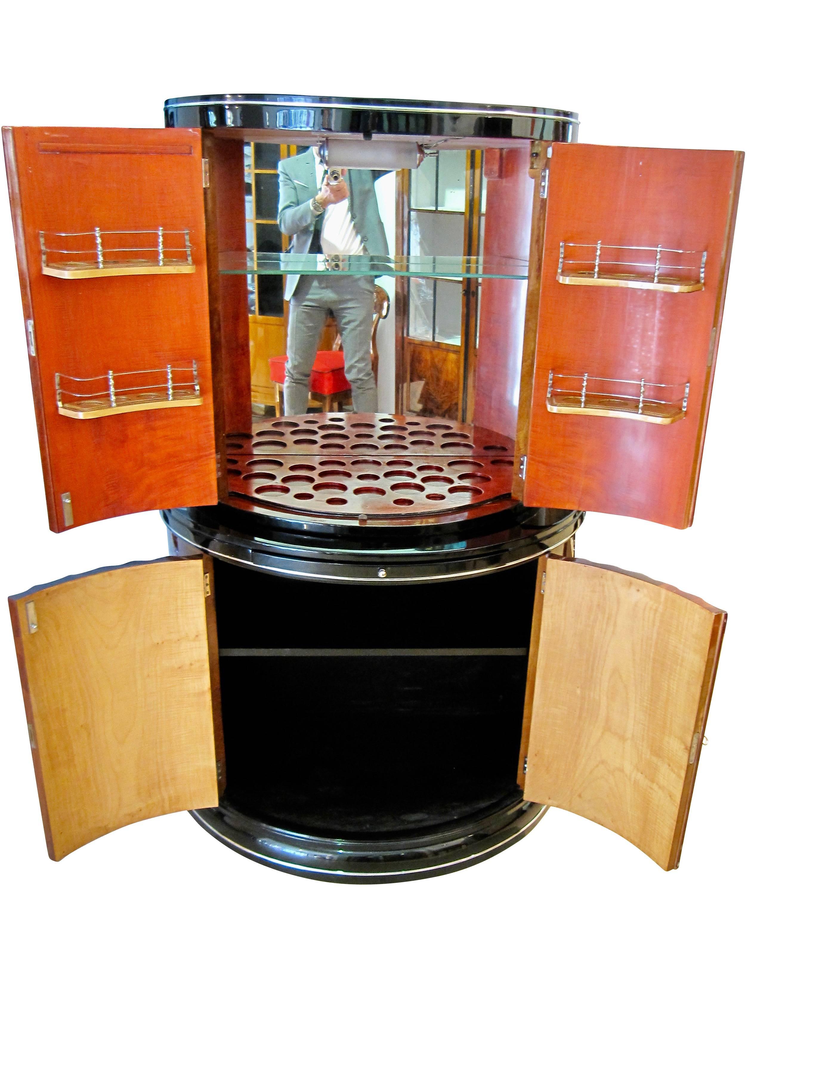 Außergewöhnlicher Art Deco Demi-Lune Bar / Drinks Cabinet von 'Harry & Lou Epstein Furniture Co.'. 

Die Bar hat vier kannelierte und kannelierte Türen und ist mit geflammtem Ahorn furniert:: der in einem walnussbraunen Farbton gedämpft ist. 

Im