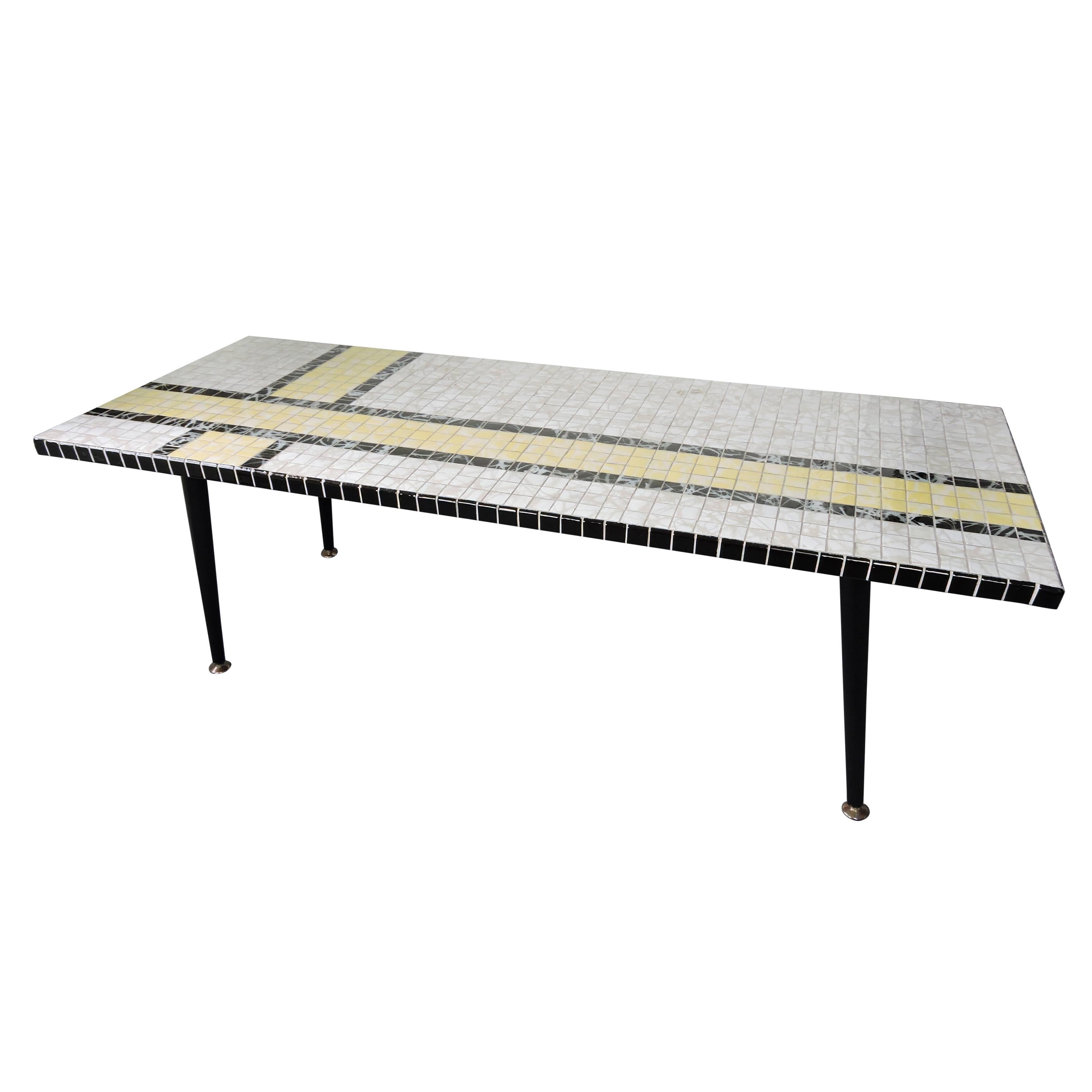 A Mid-Century coffee table featuring black, white and yellow ceramic tiles.