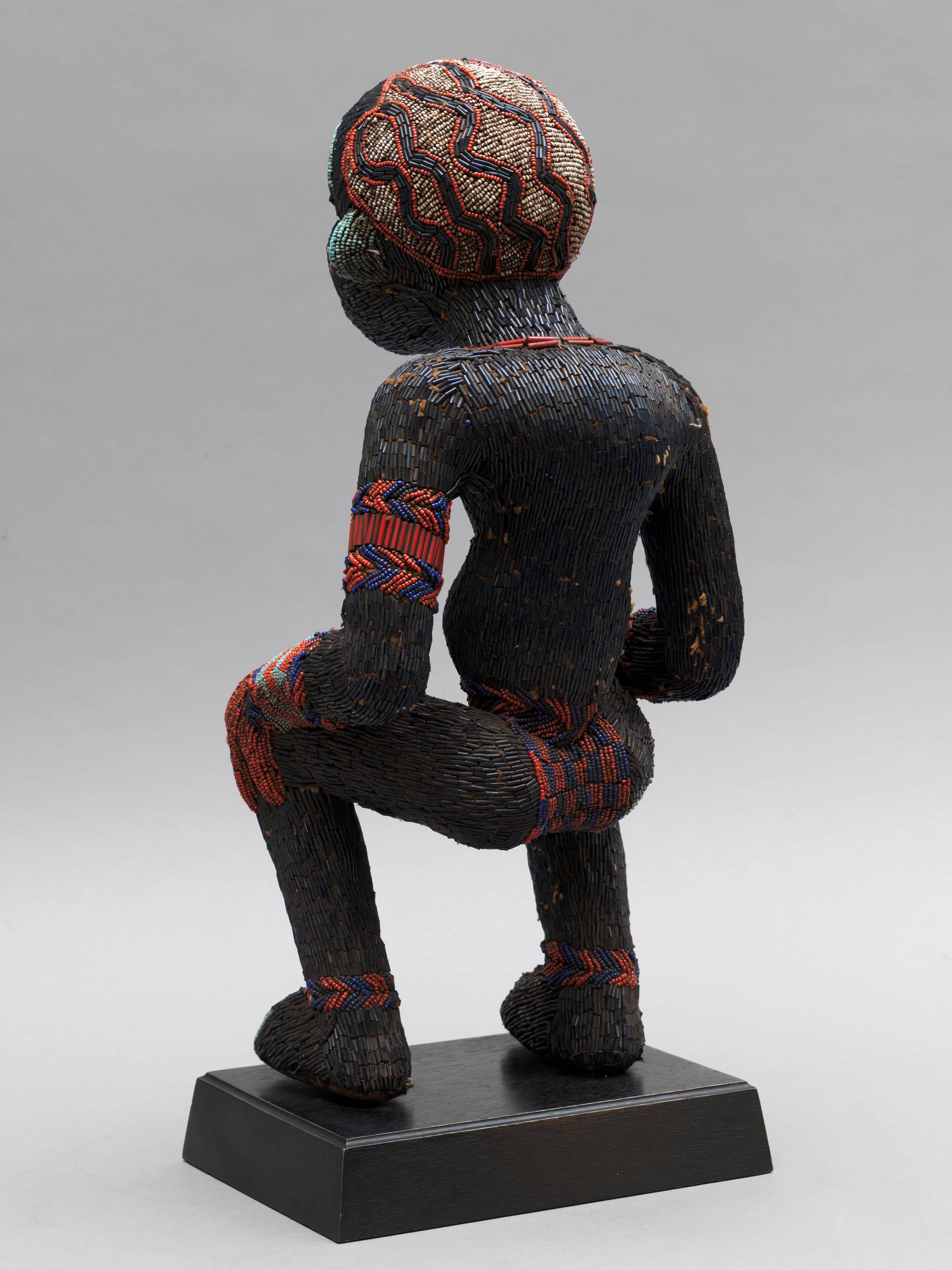 Beaded Figure were either representatives of Royal Ancestors or of Important Lineage Figures. Cameroon Art is one of the few to present figures in a non-static way. This Wooden Dancing Figure, covered in fabric and decorated with original dark blue