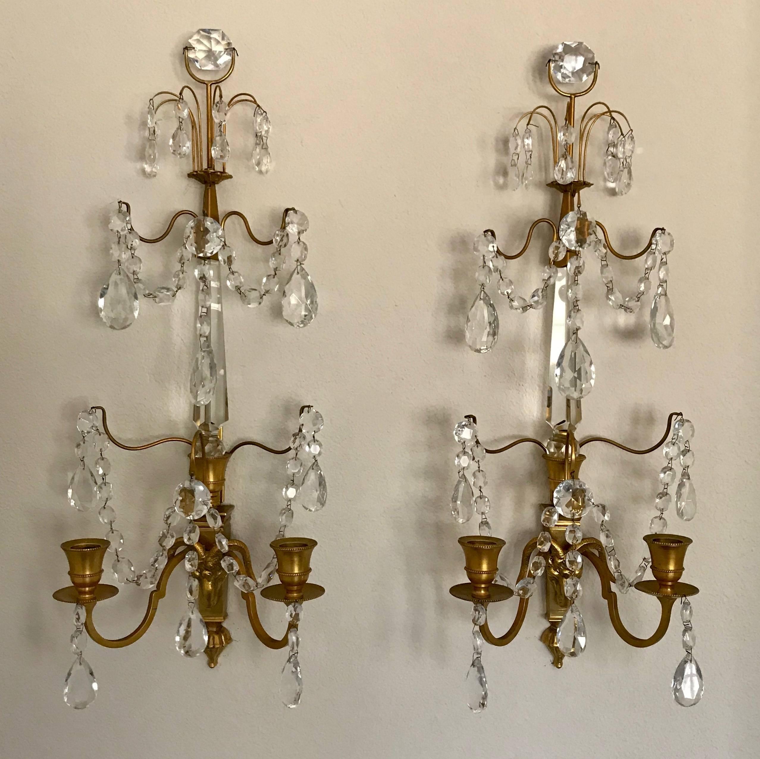 Stunning pair of Swedish or Baltic wall sconces in doré bronze with rams head motif. Two candle arms with central crystal spike and delicately draped festoons of cut crystal drops and swags. Not wired.

Measures: 20-1/2