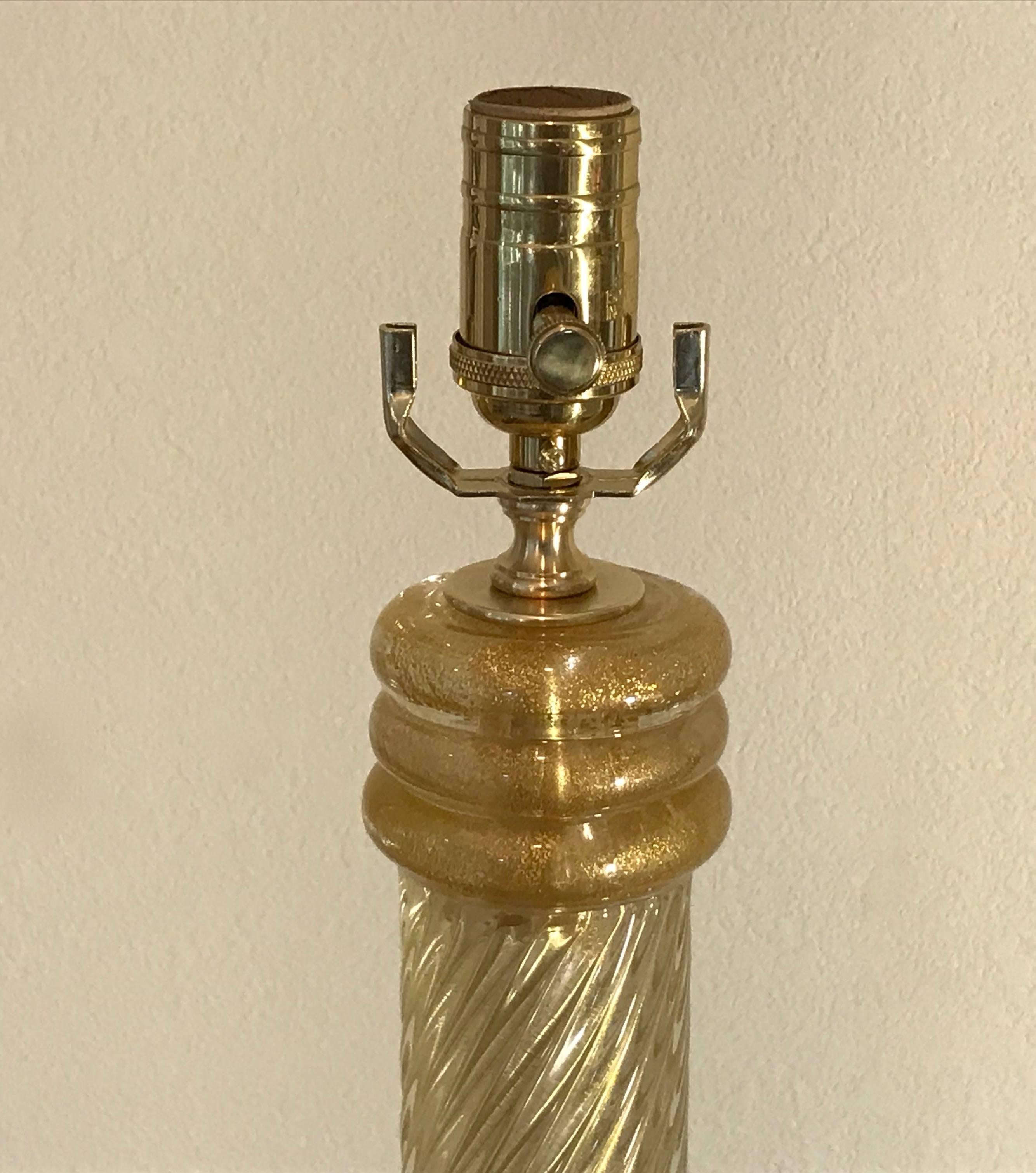 A very tall Italian Murano glass lamp composed of clear spiral ribs glass infused with 23 karat gold inclusions. Newly wired for US on custom acrylic base with full range dimmer socket, brass fittings and French style rayon covered