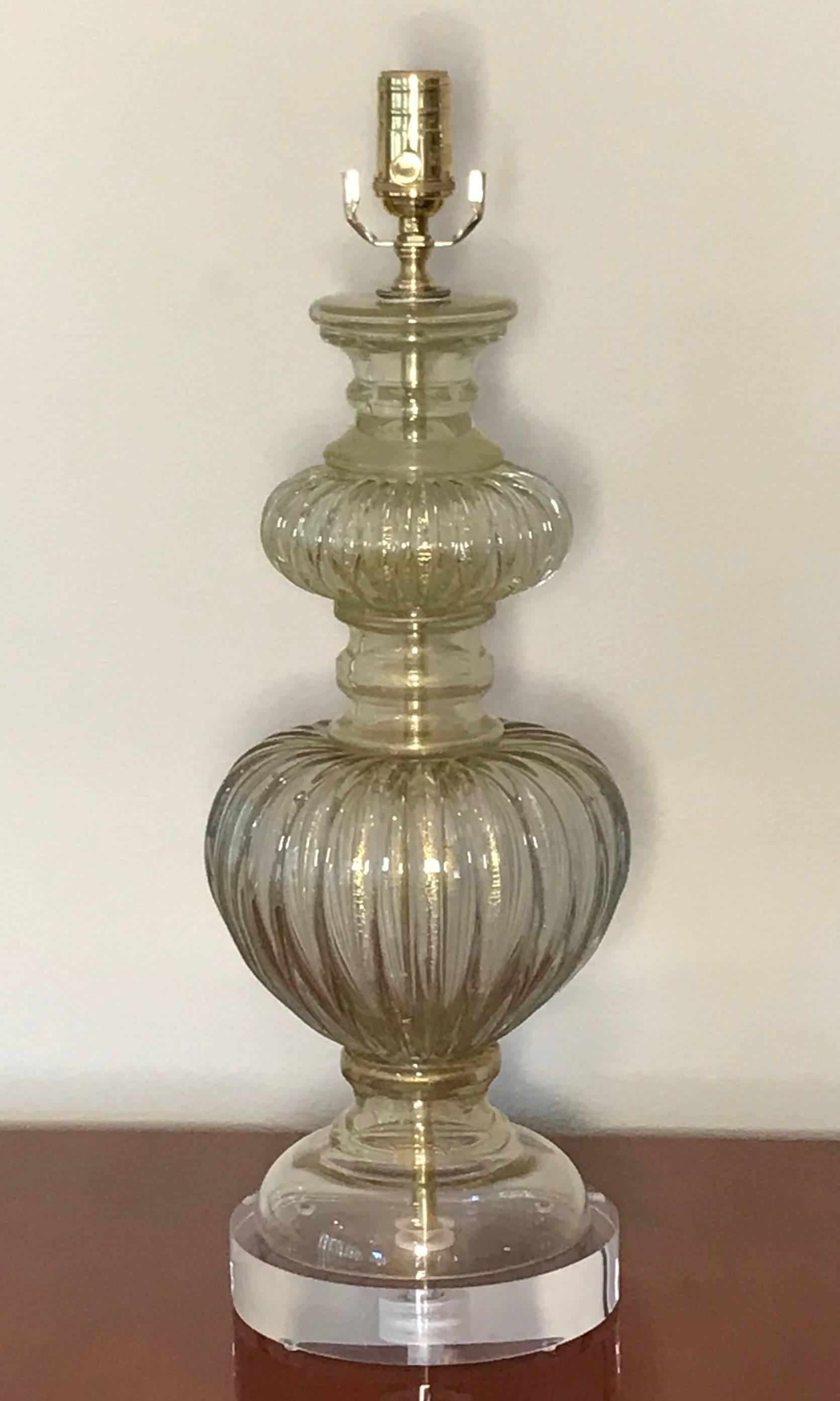 Single Italian Murano glass lamp composed of clear thick ribbed glass with gold inclusions. Newly wired for US on custom acrylic base with full range dimmer socket, brass fittings and French style rayon covered cord.

Measure: 24