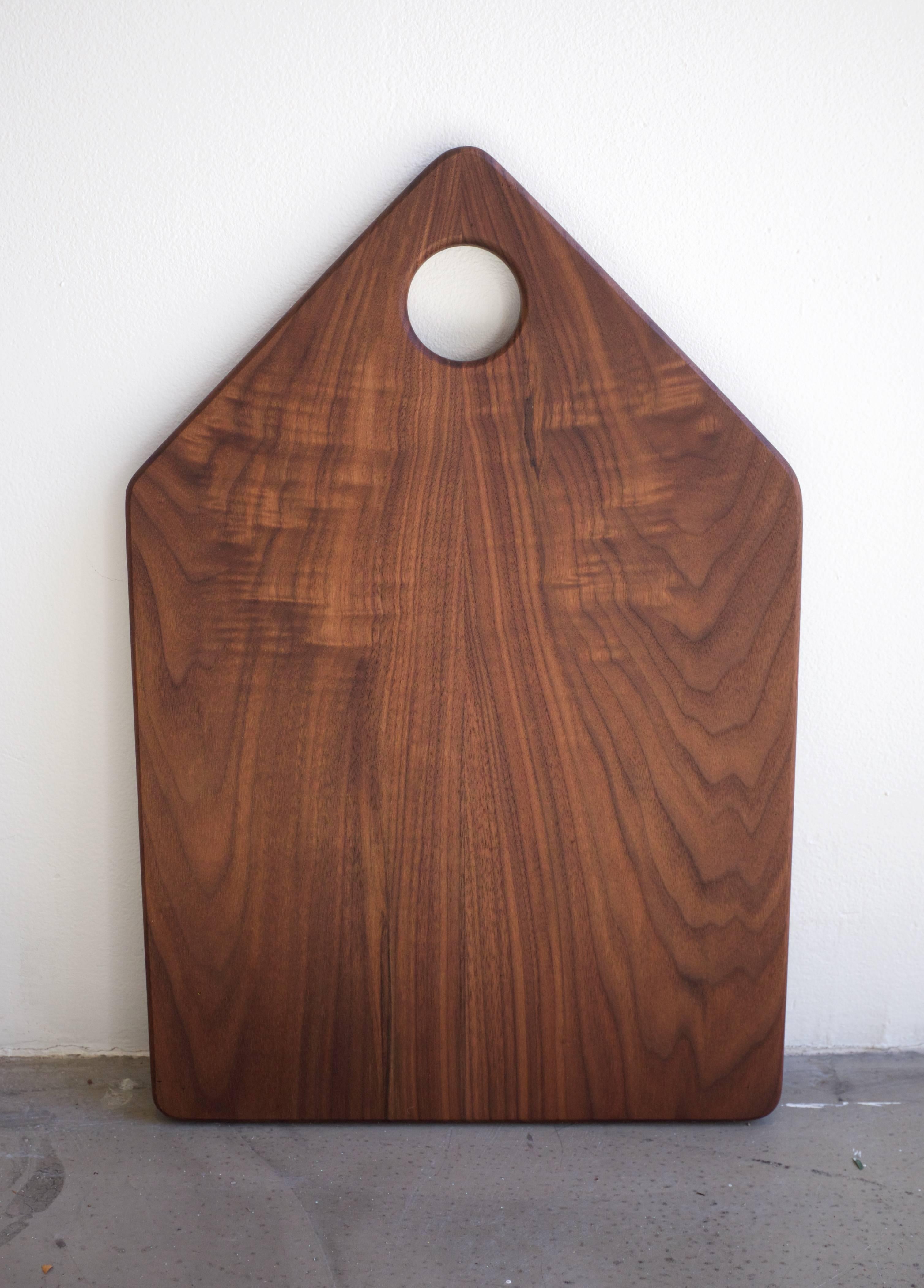 Walnut serving board handcrafted and finished. Geometric shapes set this cutting board apart, as it is modern and a beautiful addition to any kitchen set. Edges are smoothed and rounded, for an easy to use grip and softened visual.

Finished with