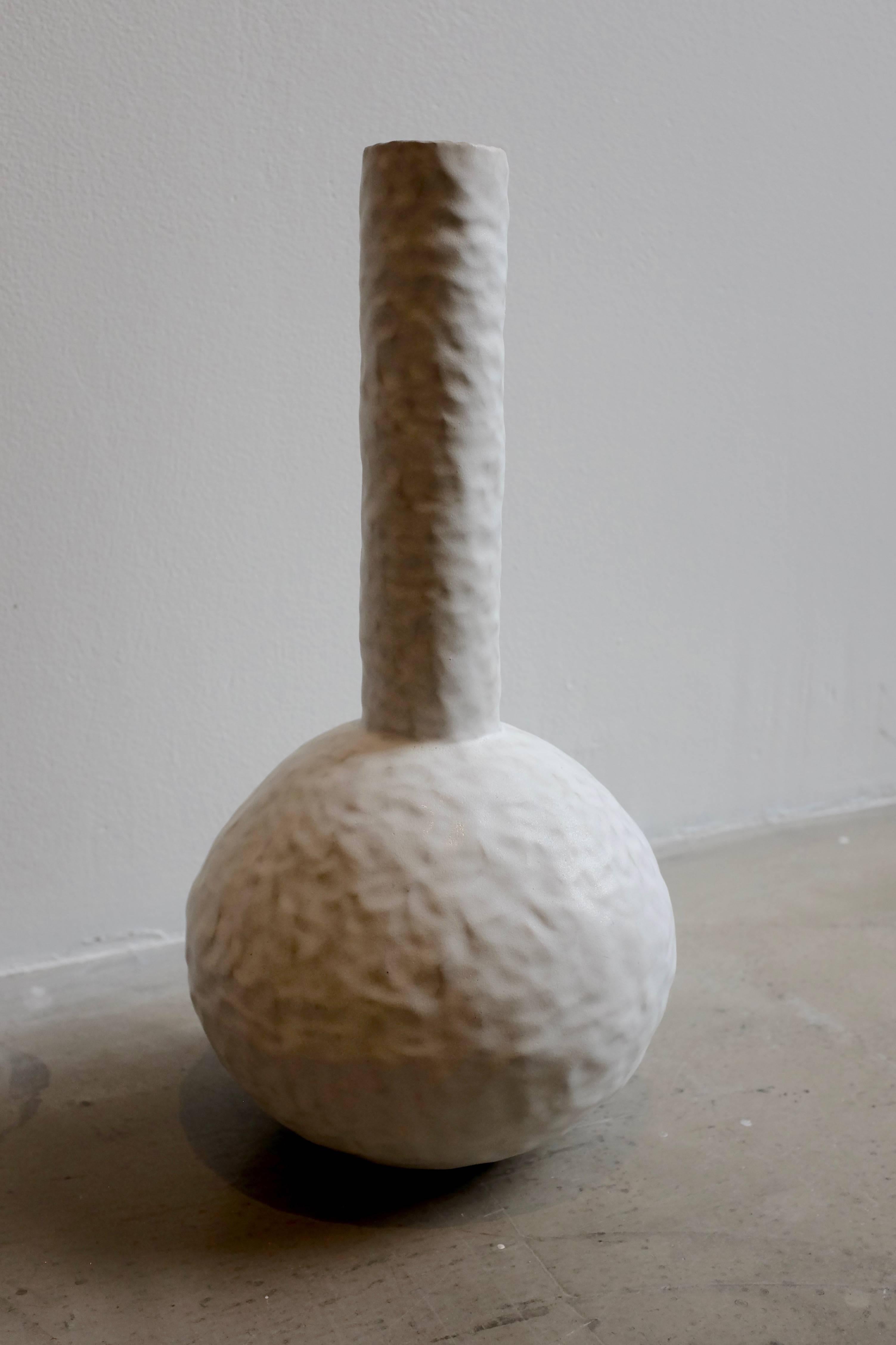 This form focused piece is constructed in stoneware using a coiling and pinching technique; the slight depressions and textures on the vases surfaces are created by the artist's fingers. Each piece is hand-sculpted and designed to create