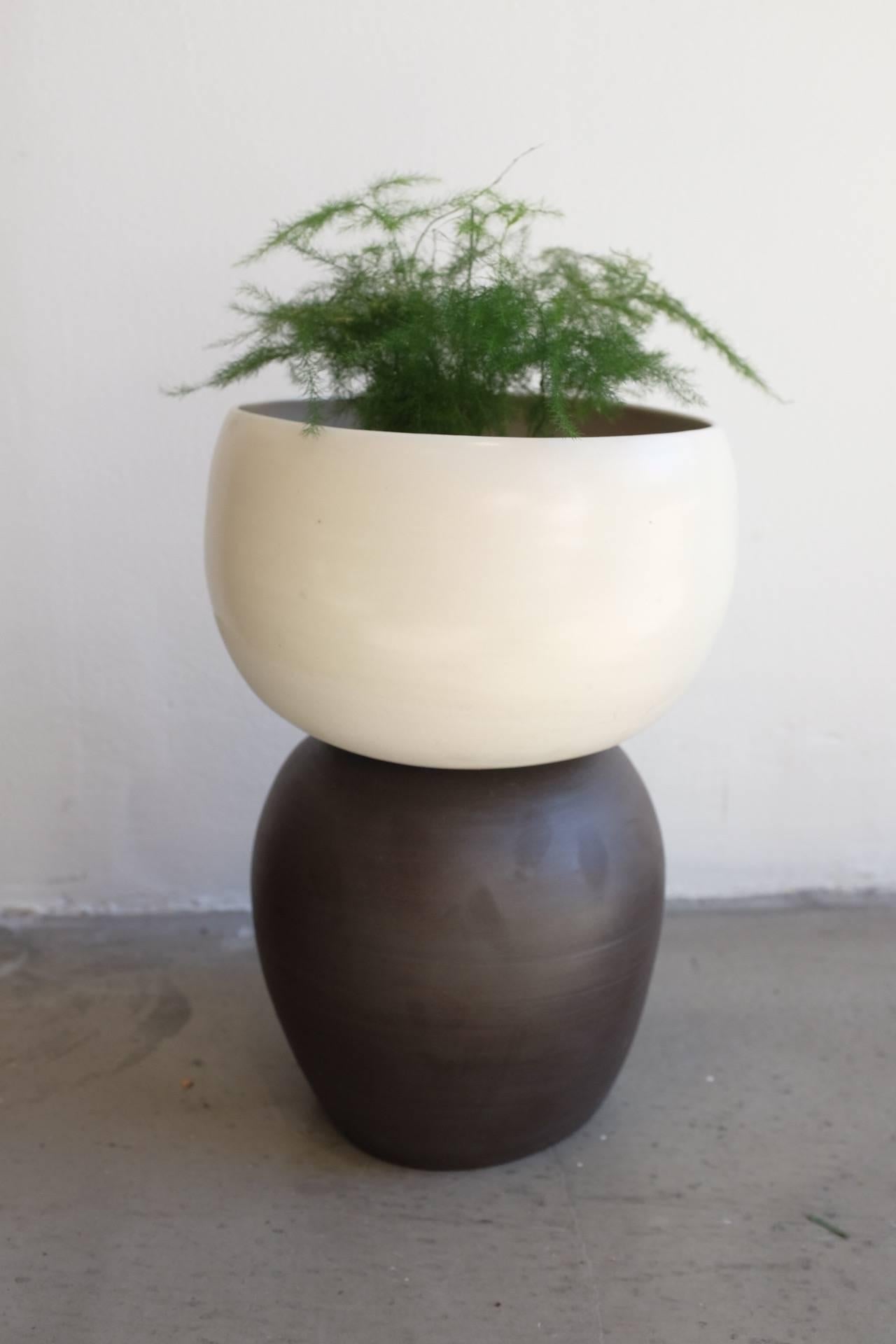 This asymmetrical planter has been hand-thrown and constructed in Brooklyn, NY. Sculptural and oddly shaped, there is a cantilever effect in the appearance. Fired at high temperatures, the porcelain is strong and softly textured. The black half of