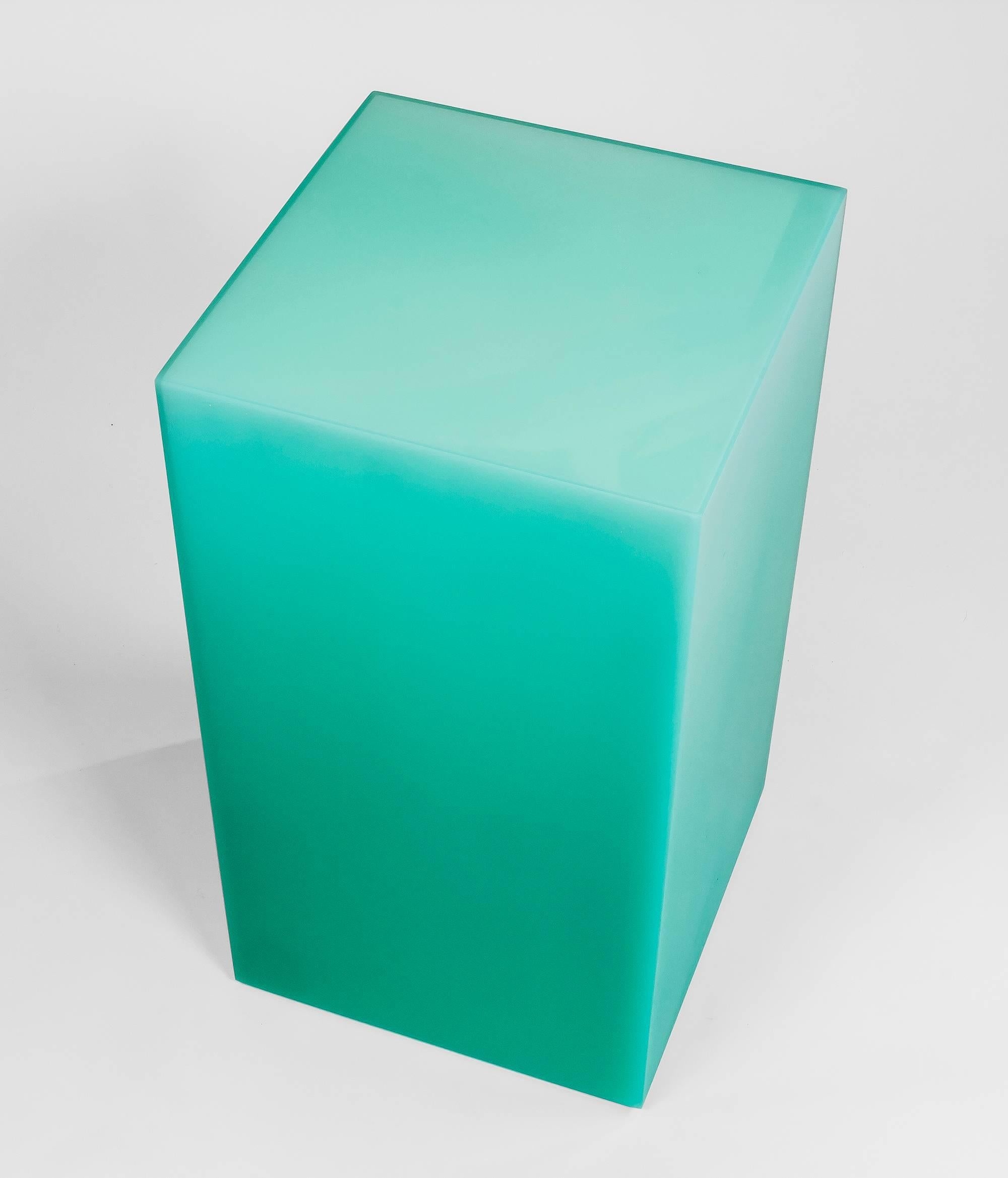 This stool / side table uses Facture Studio's Shift style to transition seamlessly from a deep opaque to water clear green over a white core. The exterior facets are sanded to a buttery smooth finish. This stool plays with light and transparency to
