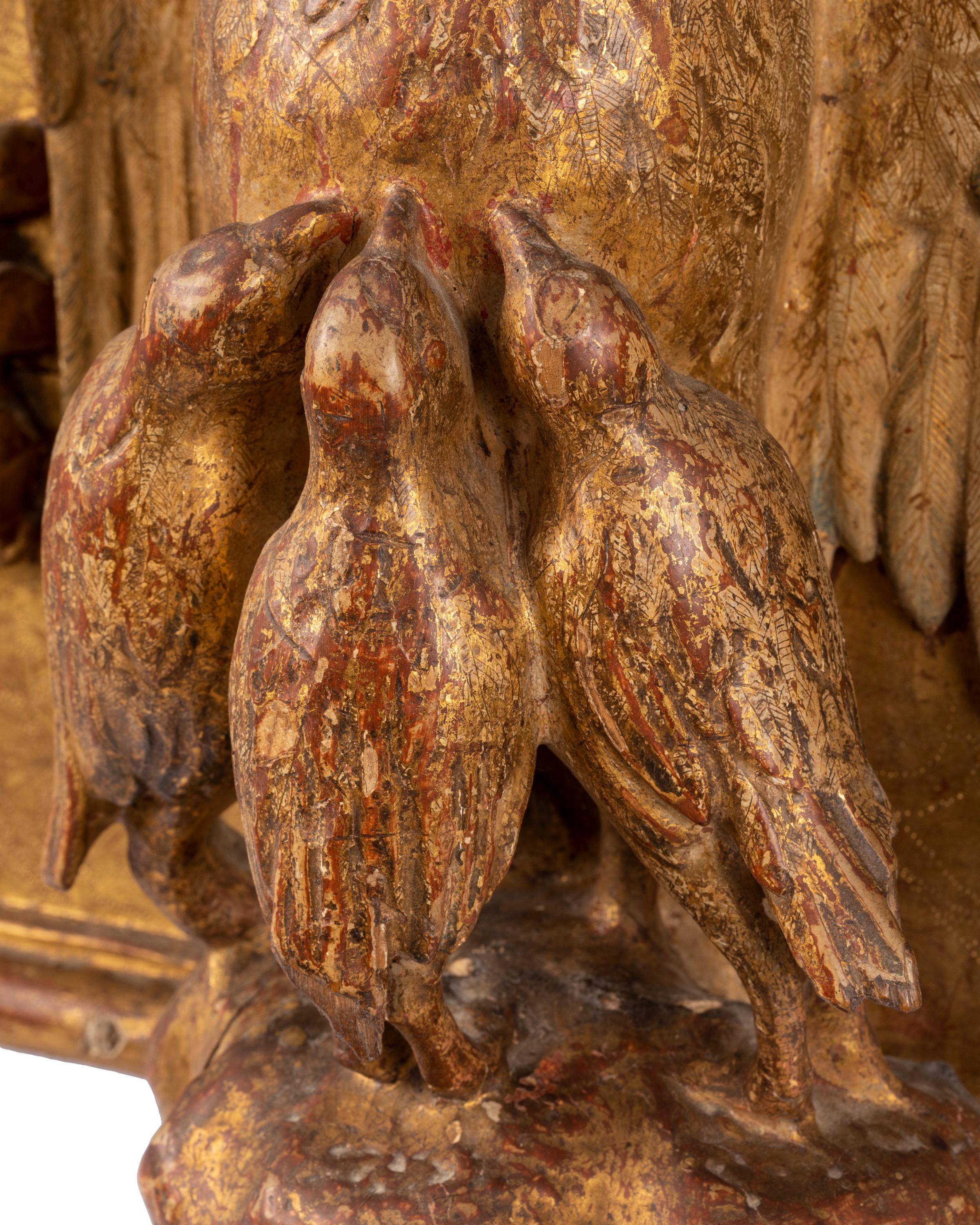Spagnolo Scultura religiosa del XVIII secolo in legno dorato con pellicano che nutre i pulcini eucaristici in vendita