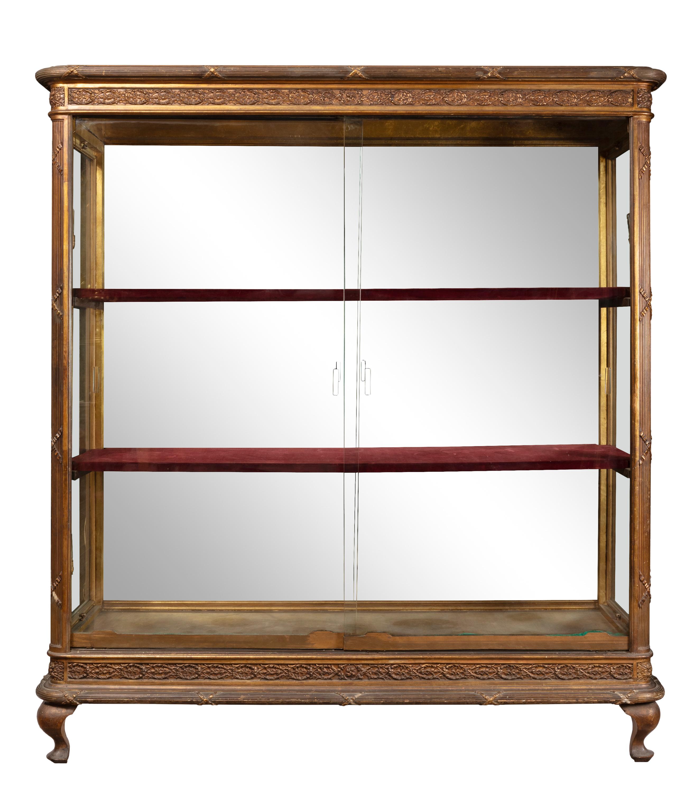 Vetrina di grandi dimensioni in stile Luigi XVI della fine del XIX secolo con porte scorrevoli in vetro e mobili in legno rifiniti in oro, decorati con motivi neoclassici. I lati sono in vetro e il retro interno è costituito da due grandi pannelli a