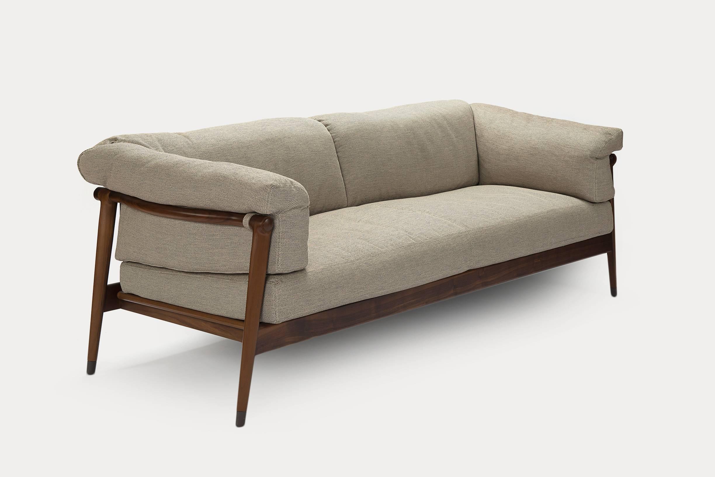 Derby sofa is a comfortable Nordic inspired jewel of a sofa which warms a room with reflections of wood, adapting itself to different solutions. Shown in Loft Cappucino fabric and Canaletto Walnut Frame.  
