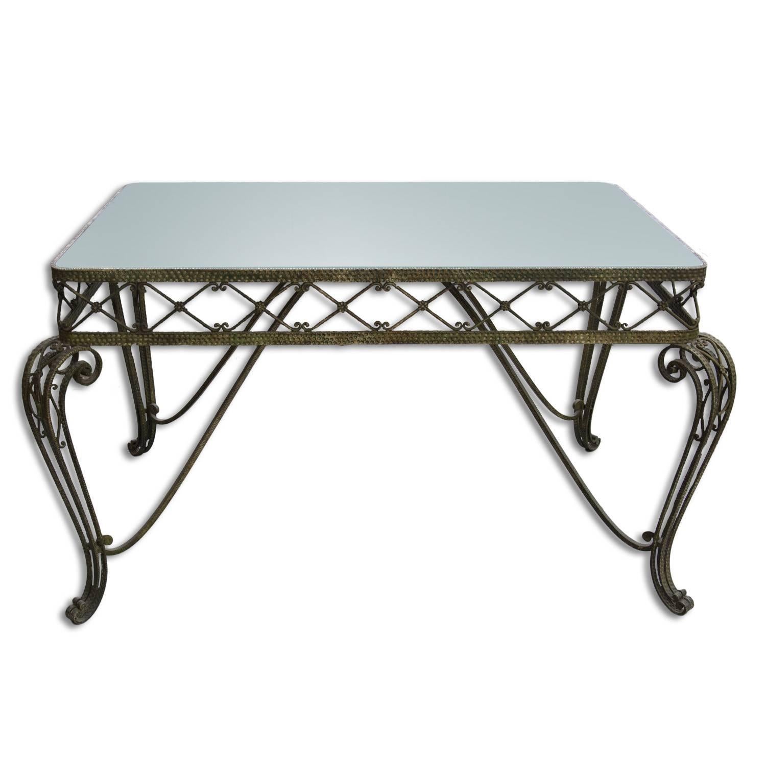 This large massive Regency style table was made in Italy in the 1950s. Attribute to Pier Luigi Colli. The table features a light green glass plate and a brass structure with decorative motifs typical of this style and period.