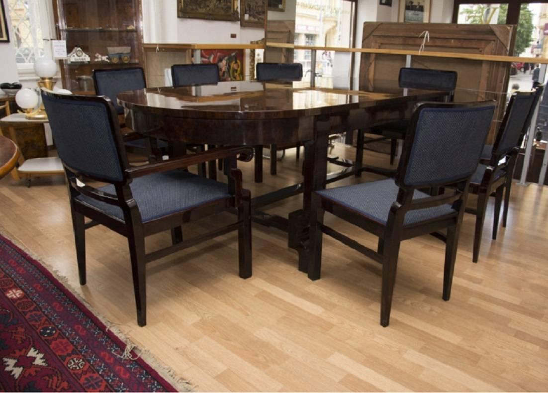 This dining set seats 8 people and features a large walnut veneered dining table with six chairs and two armchairs. It was thought to have been made in western Europe sometime in the 1930s. The set has been professionally renovated; the wood has