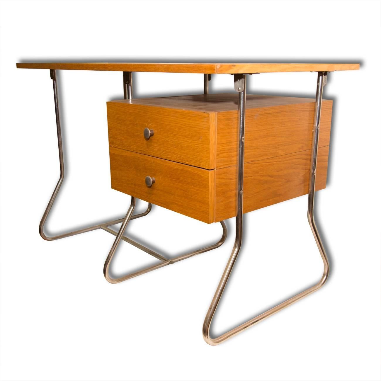 This writing desk was manufactured in the 1950s in post-war Czechoslovakia and produced by Kovona - a company producing metal and chrome-plated furniture. It features a simple design, made of bent chrome-plated steel and veneered plywood. In