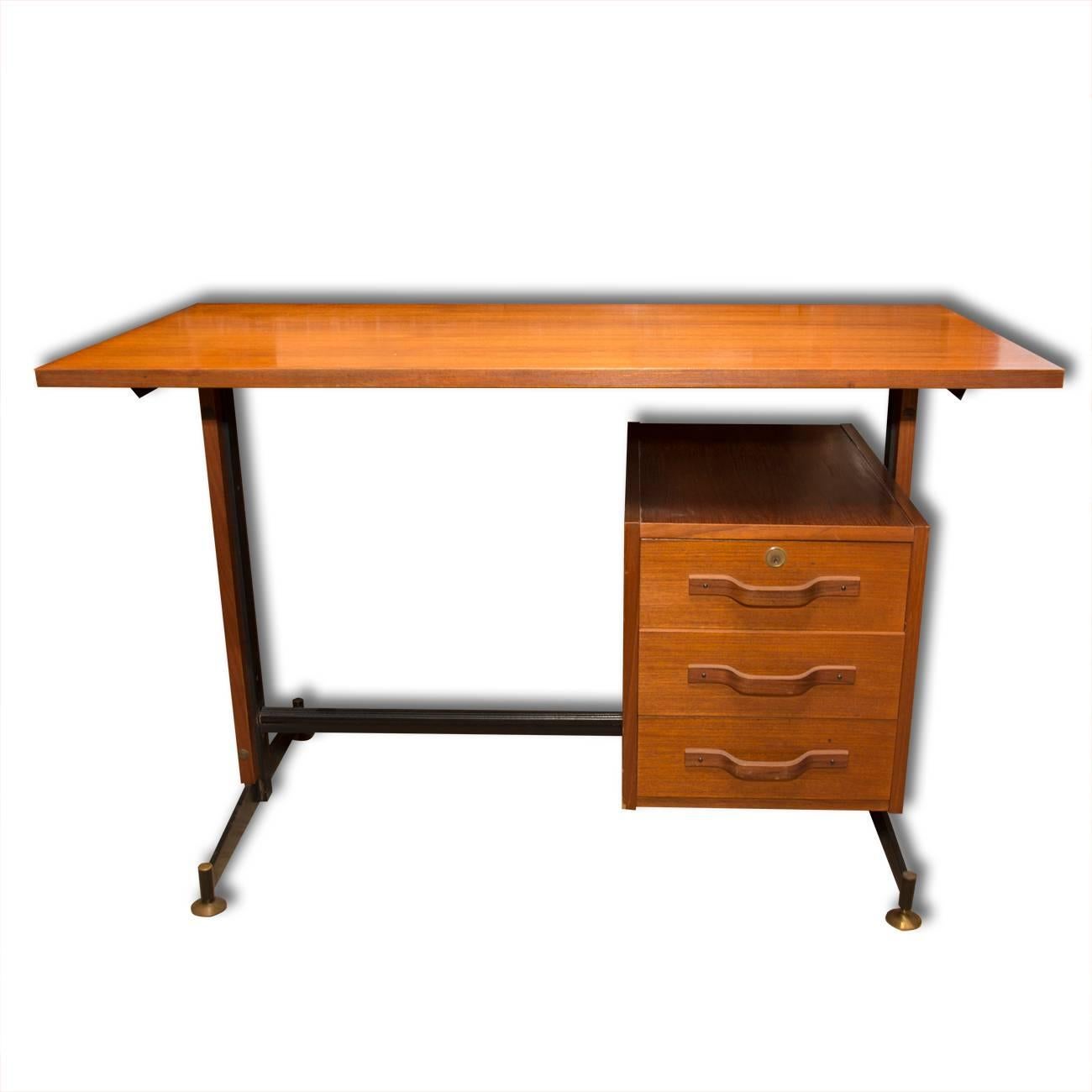 Mid-century Italian teak writing desk with chair made in the 1950s. The writing desk is in the style of Osvaldo Borsani’s for Tecno. Both pieces have been very well-preserved. The table features an iron structure with brass ends and the chair