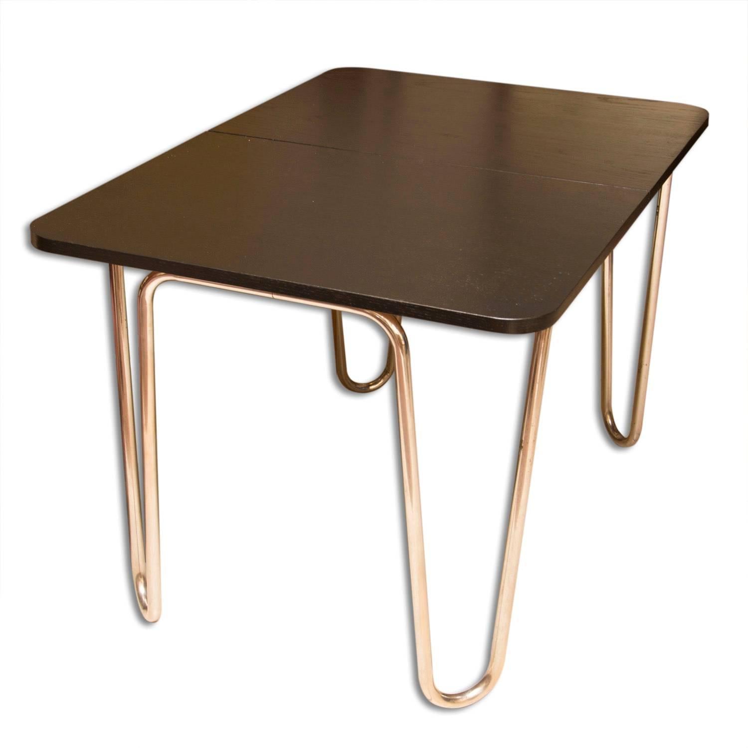 This folding dining table was made in Bohemia in the 1930s by the famous company Robert Slezak. The table features a chrome-plated metal base and dark stained oak top. Chrome structure is in very good Vintage condition. Table length after unfolding