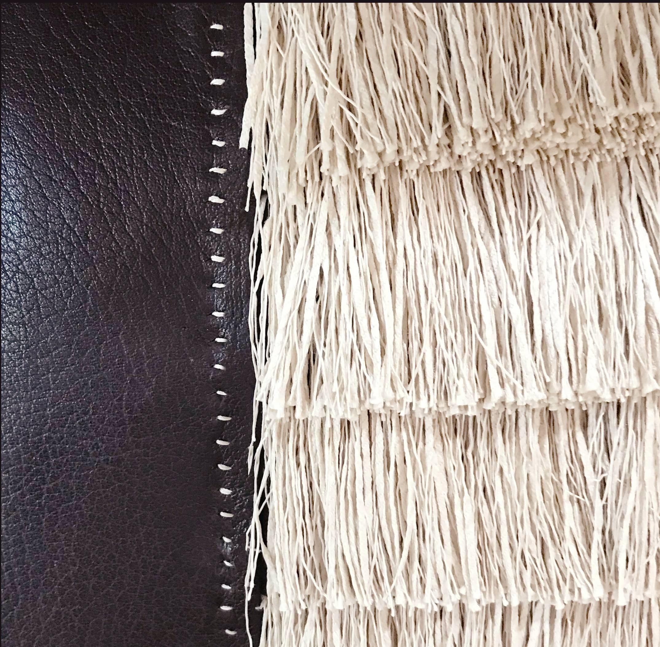 A fine  calf leather has been meticulously hand stitched to showcase the three inch raffia fringe.  The hand stitching and the inset fringe create a truly couture pillow 

Details
	•	Fine calf leather 
	•	Hand stitching detail  
	•	Includes down