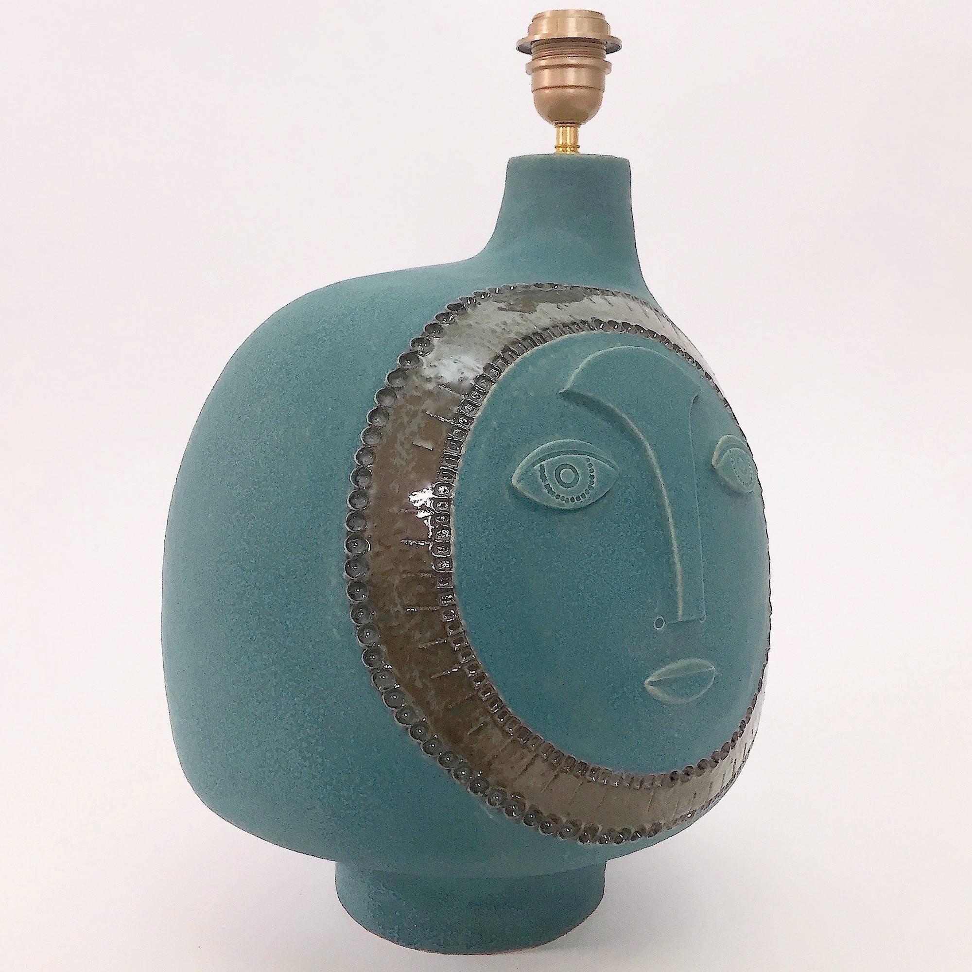 Large hand-sculpted ceramic lamp base, biomorphic shape. 
Stoneware glazed in shades of matte blue-green / dark turquoise, decorated with a stylized visage sculpted and incised in front, and over-glazed in shades of cloudy dark sea-gull