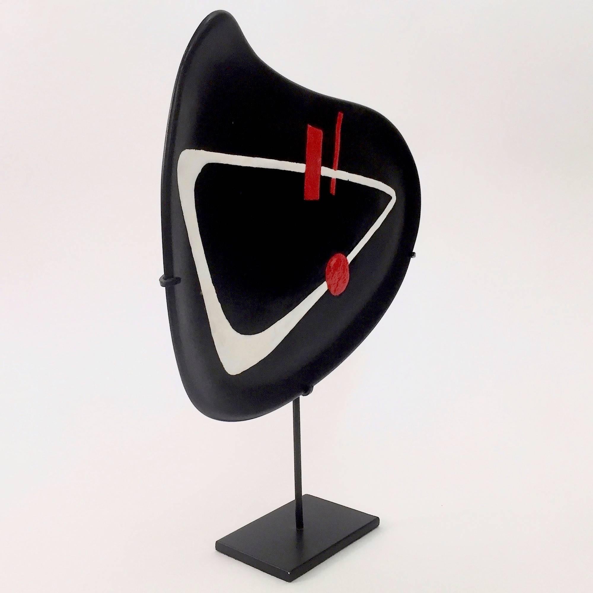 An organic shaped earthenware dish glazed in black with abstract and geometric decoration engraved and over-glazed in shinny white and red. 

Typical Mid-Century Modern abstract and geometric design, reminiscent of Joan Miro´ or Calder mobiles