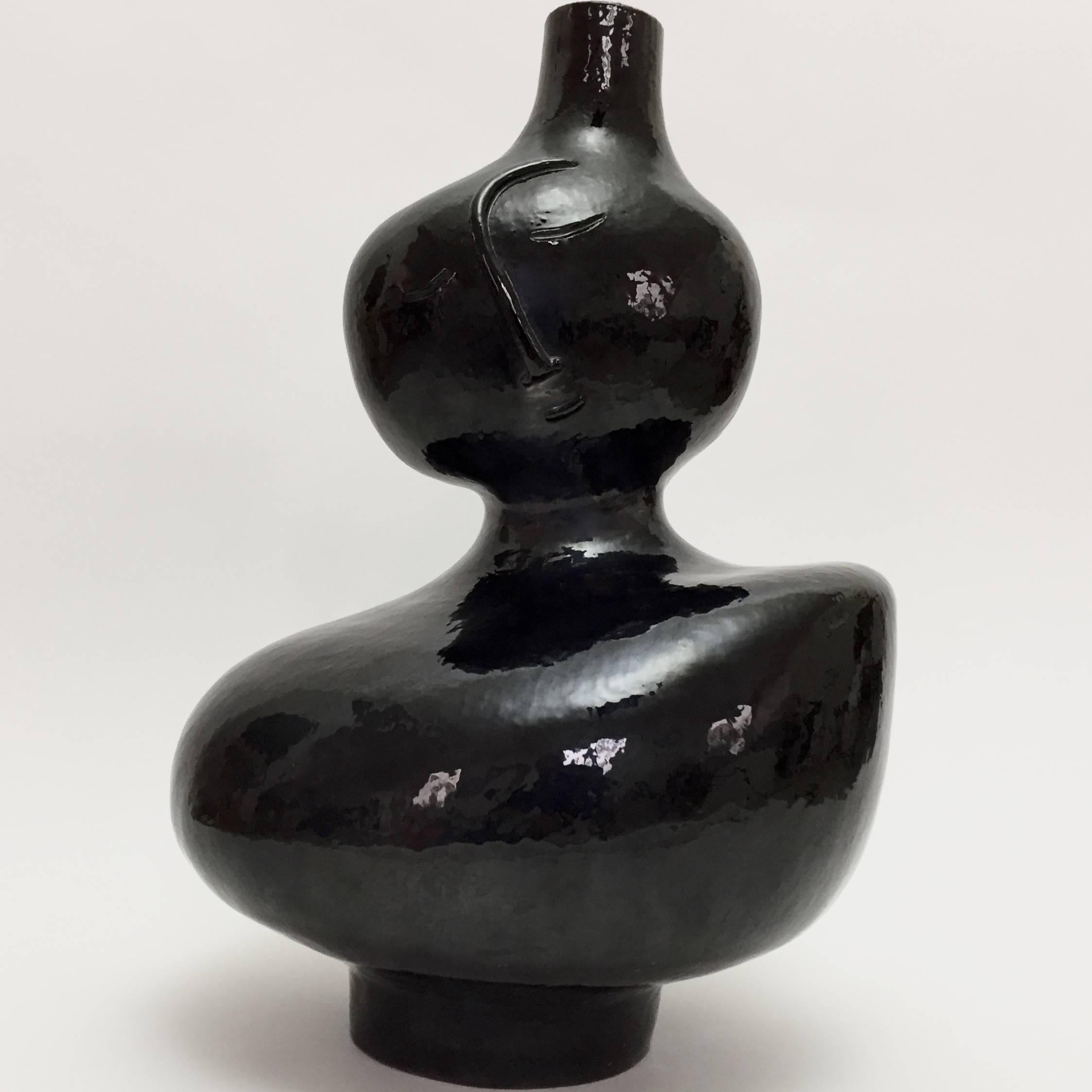 Large biomorphic sculpture forming lamp-base.
Stoneware glazed in glossy black and decorated with a stylized visage on front.
One of a kind handmade piece designed and signed by the French ceramicists, Dalo. 

Note to international purchasers: