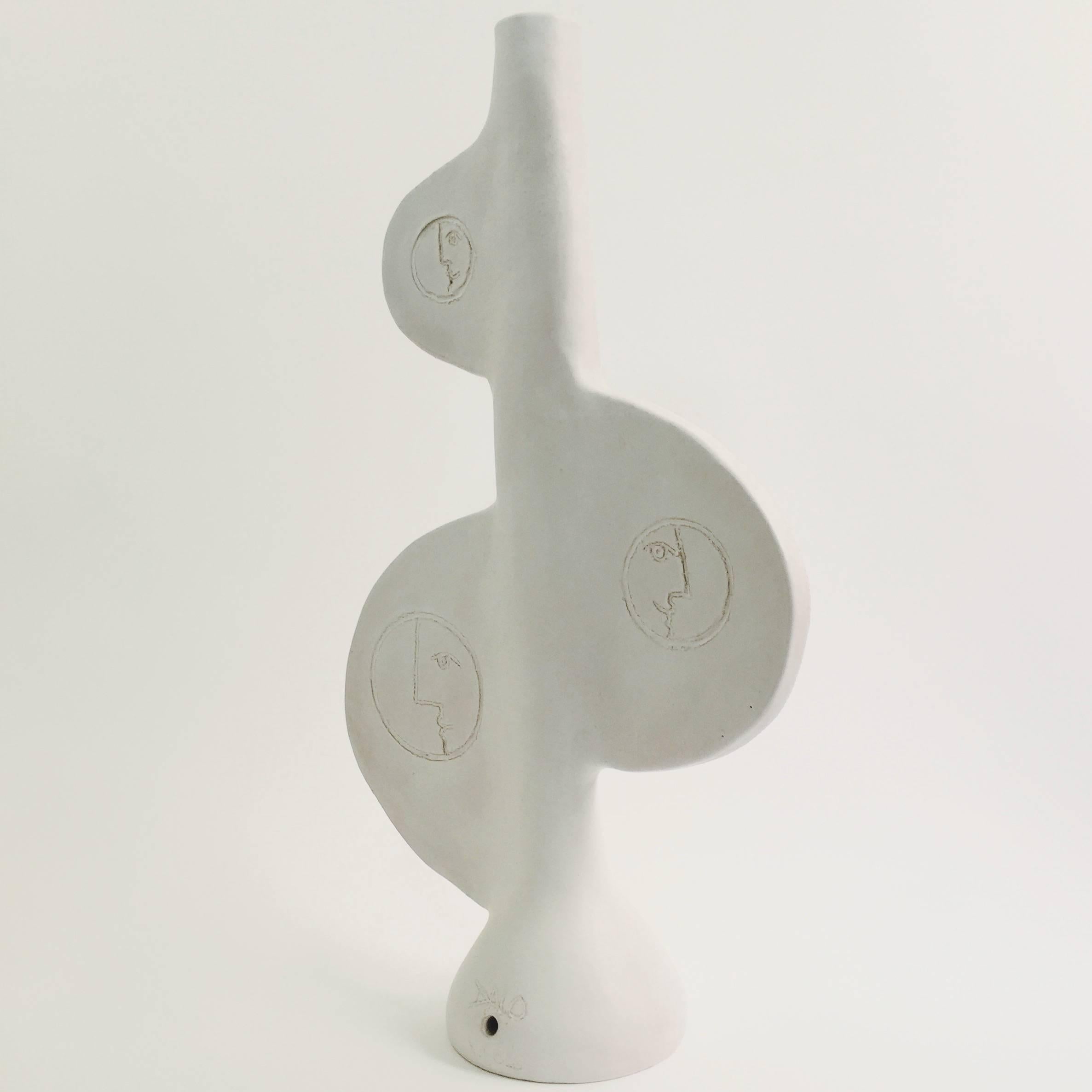 Large totem sculpture or could be also displayed as a biomorphic lamp base.
Stoneware glazed in white and decorated with stylized faces sculpted front and incised back.
One of a kind handmade piece designed and signed by the French ceramicists,