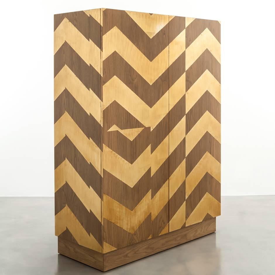 The Cambria Cabinet features a gold leaf fractured chevron pattern over an oak frame.  The interior standard comes with 4 drawers and shelves and can be customized to any interior needed whether it be a wardrobe, bar, jewelry or storage interior. 