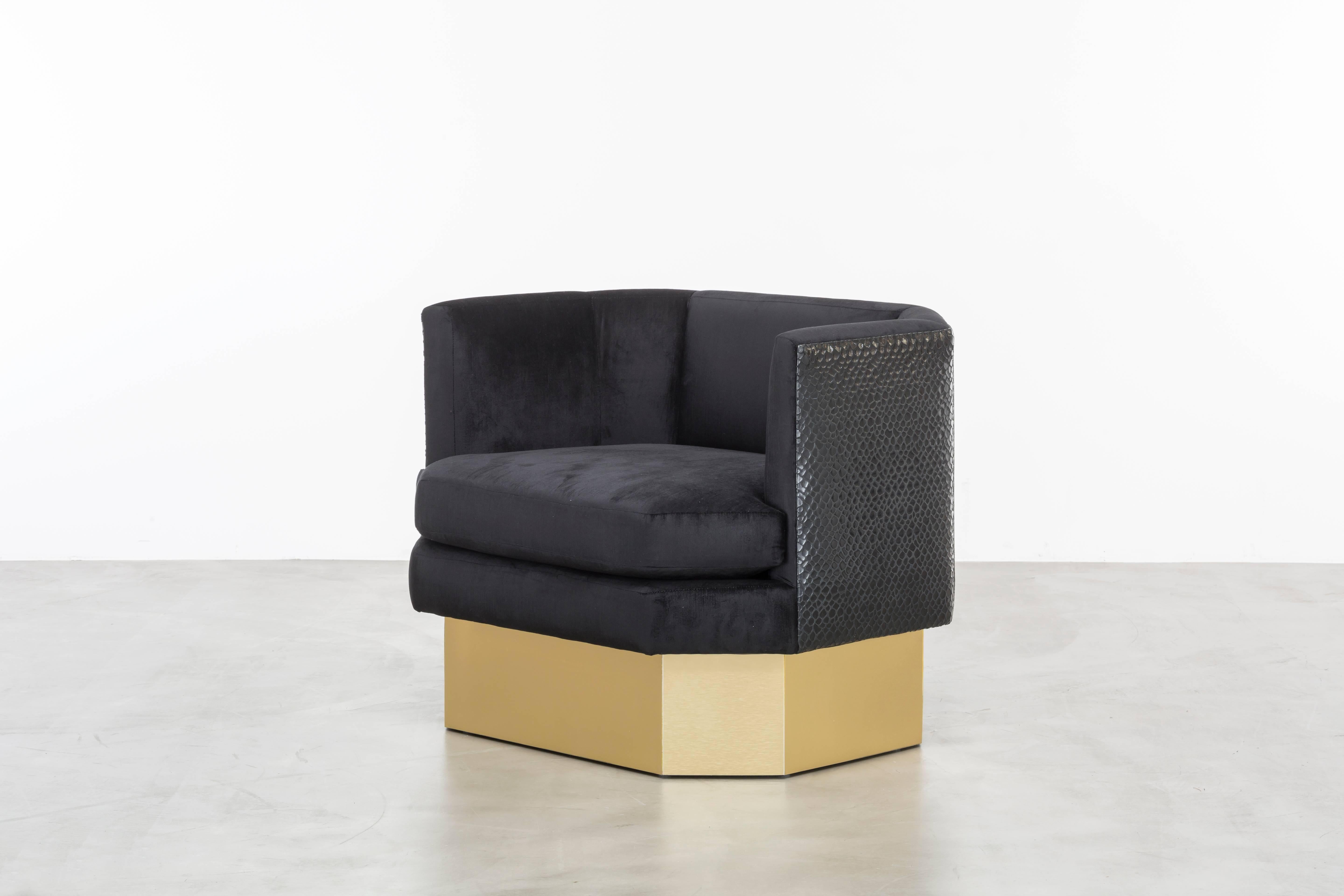 OCTAVE CHAIR- Modern Lounge Chair in Black Velvet

The Octave Chair is a stunning piece of furniture that features an octagonal-shaped upholstered velvet seat and back with contrast leather back panels. The chair sits atop a brushed brass plinth