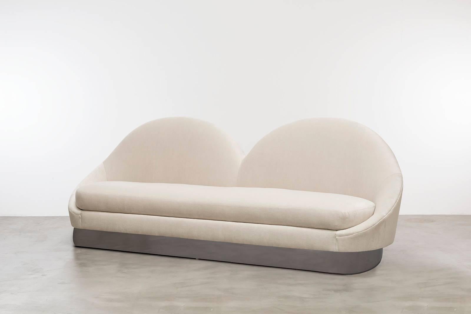 DALI SOFA - Modern Sofa in Cream Velvet

The Dali Sofa is a stunning and unique piece of furniture that draws inspiration from Gaudi architecture. Its symmetrical velvet slopes and racetrack-shaped plinth base create a minimal yet elegant look,