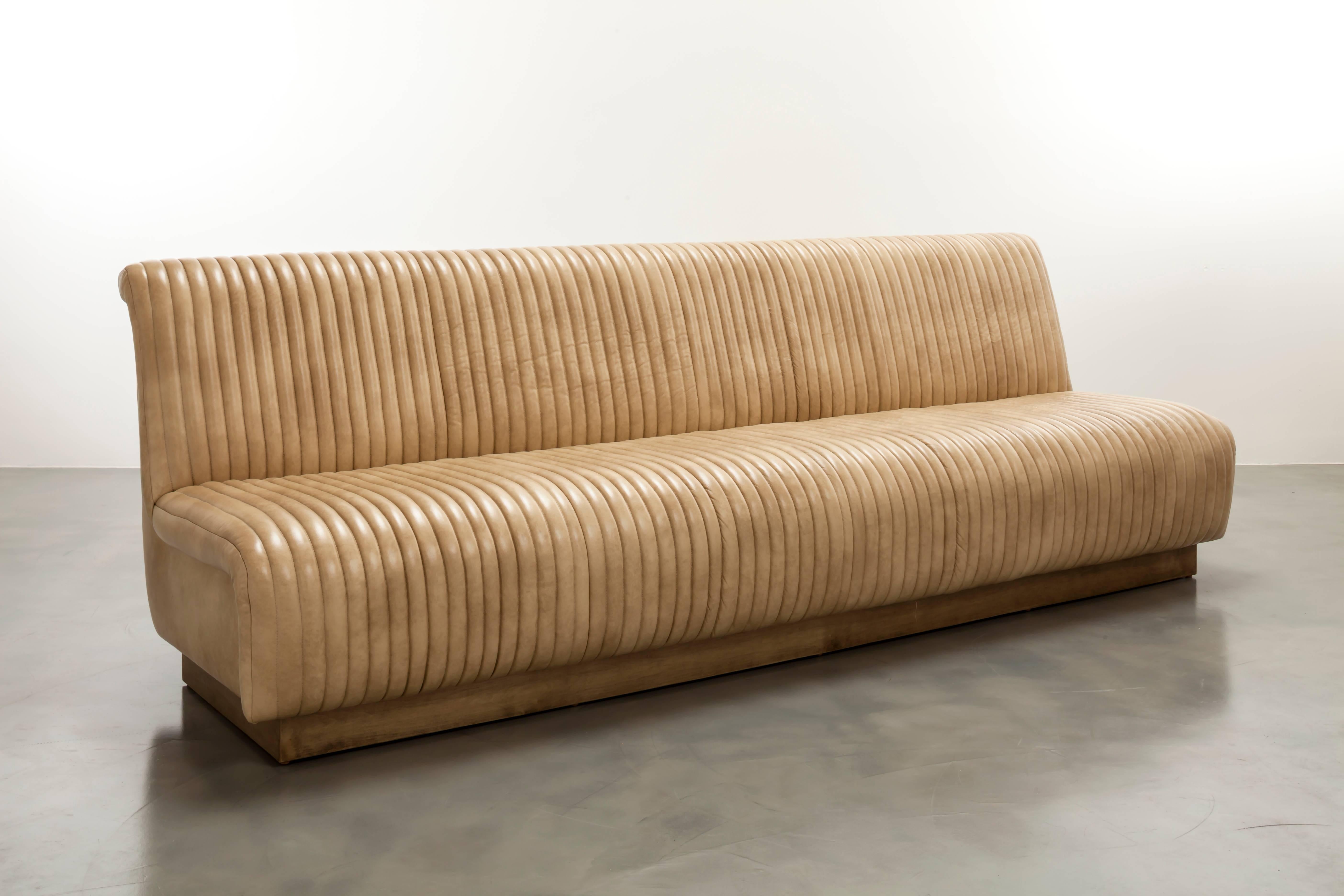 The Channel Sofa inspired by vintage car interiors features channeled waterfall leather on a wood plinth base.   Fully custom and made to order in California. As shown in Leather $15,170.  Starting at $9,950.