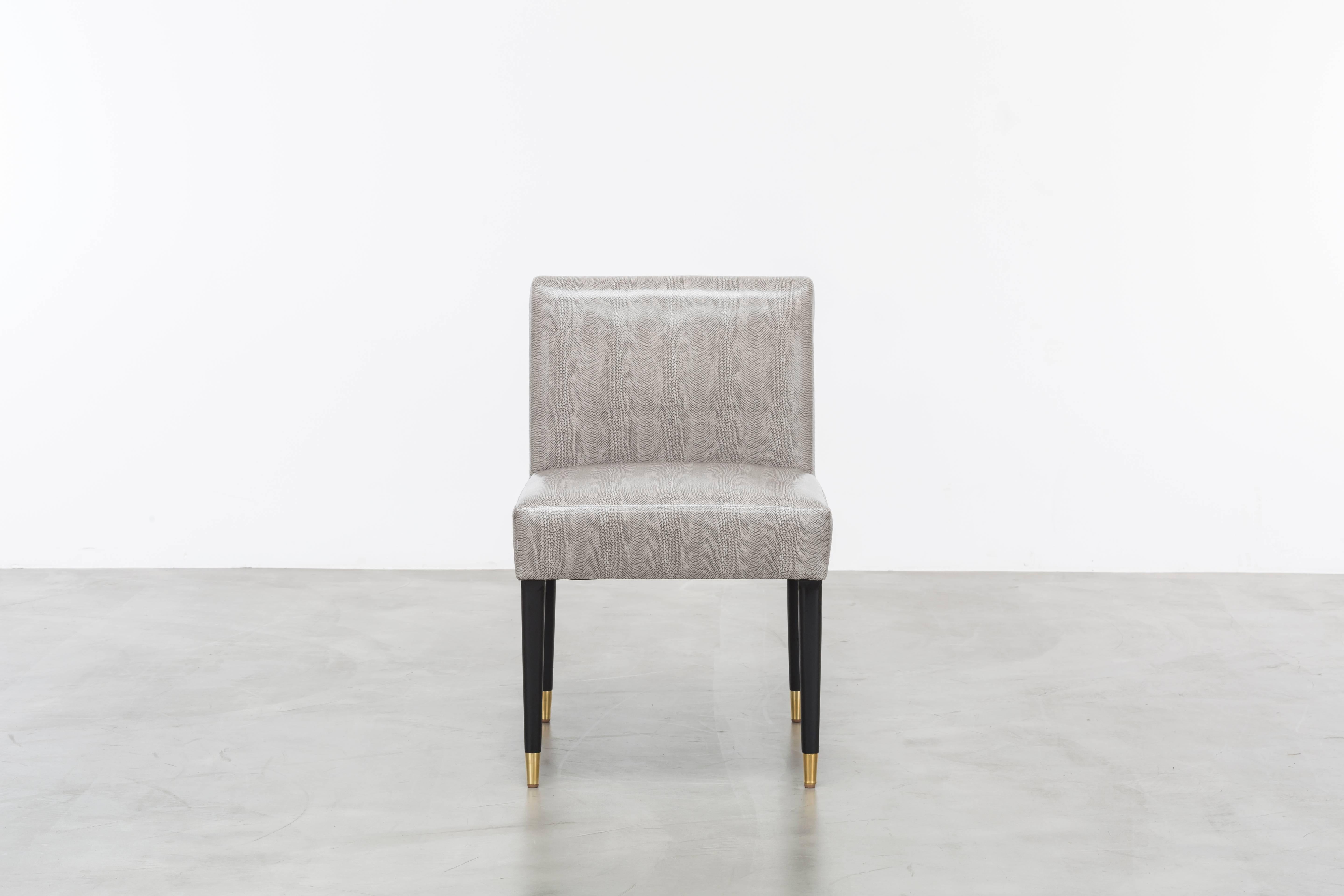 The Herve Chair is a minimal modern side or dining chair featuring a wood frame and metal ferrules.  Fully custom and made to order in California.  As shown in Snake Vinyl $4,080.00.  Starting at $3,700.00.