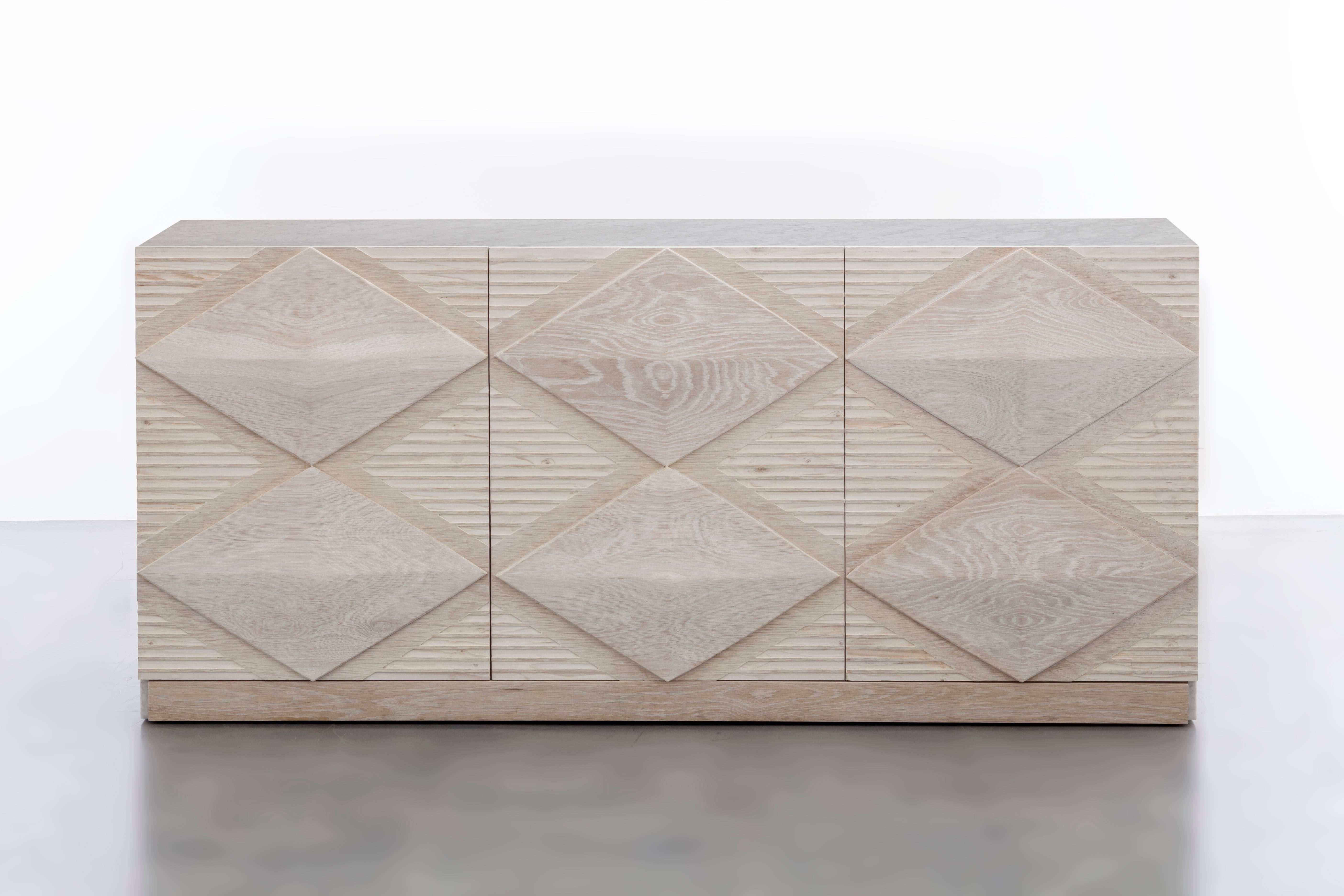 INES BUFFET CABINET - Modern Bleached Oak with Hand_Carved Design and Marble Top

The Ines Buffet Cabinet is a stunning piece of furniture that features a bleached white oak body with hand-carved oak diamond details and a luxurious waterfall Carrara