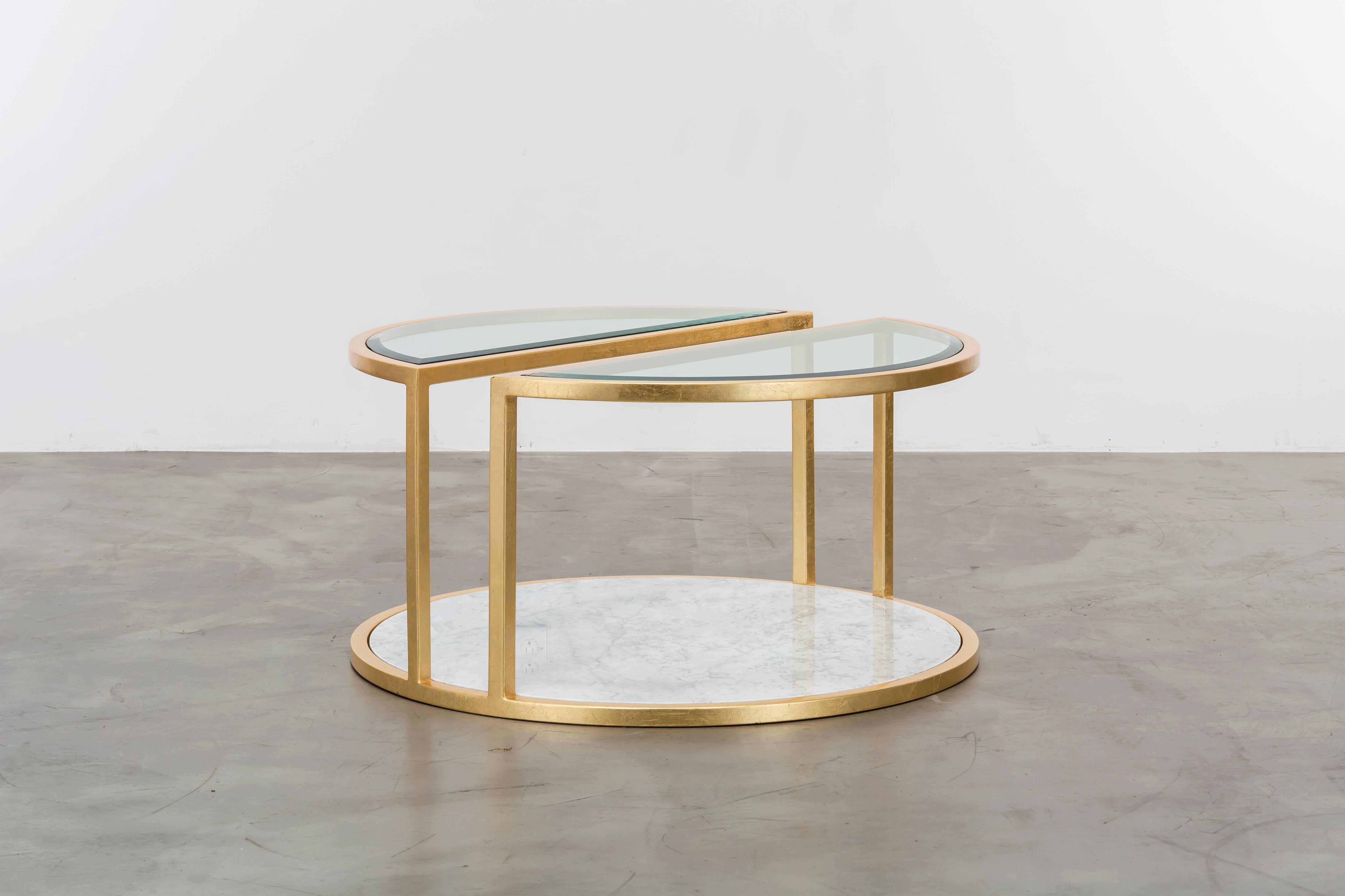 The Kais coffee table is a modern round gold leaf cocktail table made of gold leaf over iron with Carrara marble and bevelled edge glass. Fully custom and made to order in California.