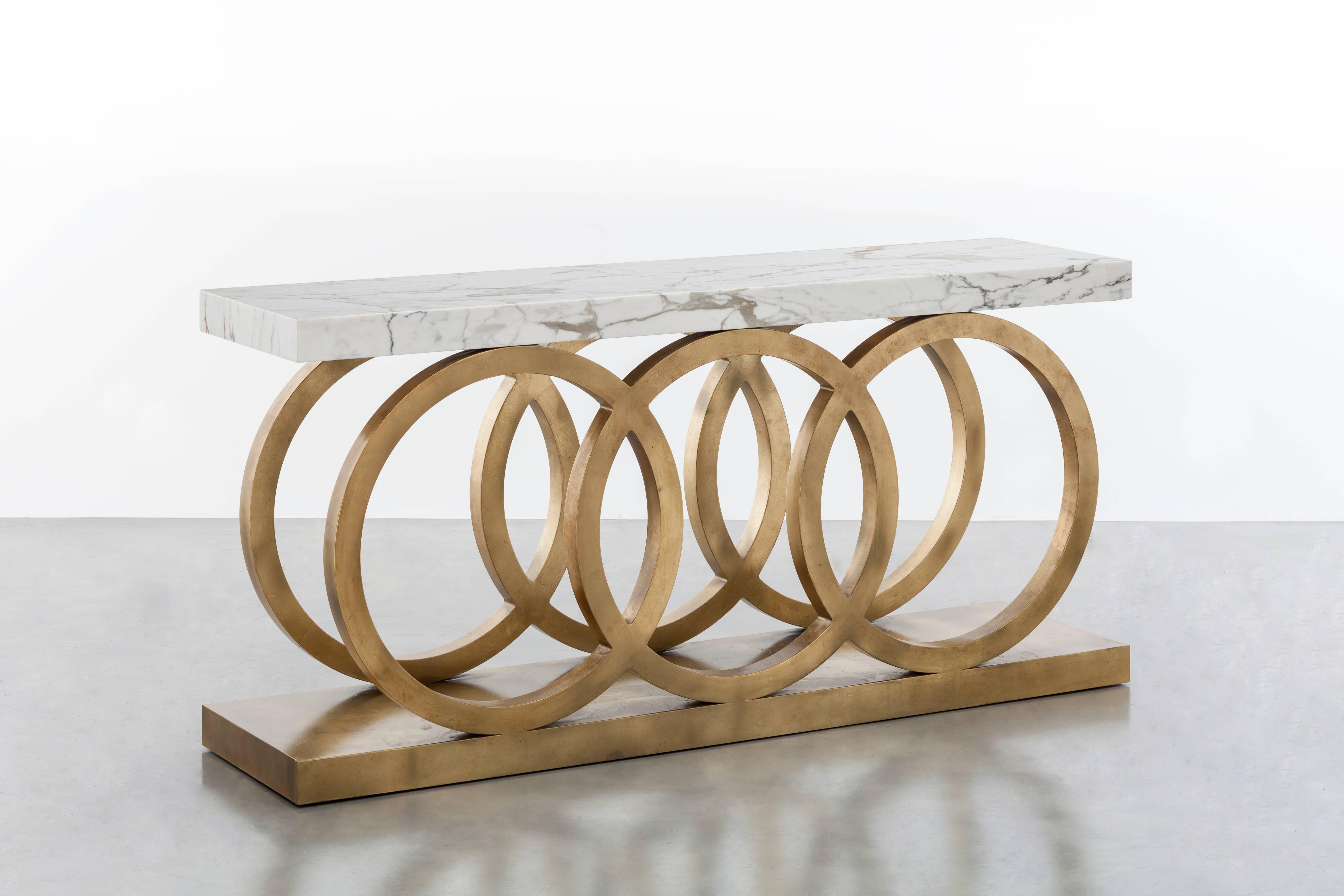 OSLO GRANDE CONSOLE – moderner runder Tisch mit Blattgold und Carrara-Marmor

Der Konsolentisch Oslo Grande ist ein luxuriöses und modernes Möbelstück, das sich perfekt für gehobene Innenräume eignet. Der atemberaubende Rahmen aus Blattgold und die