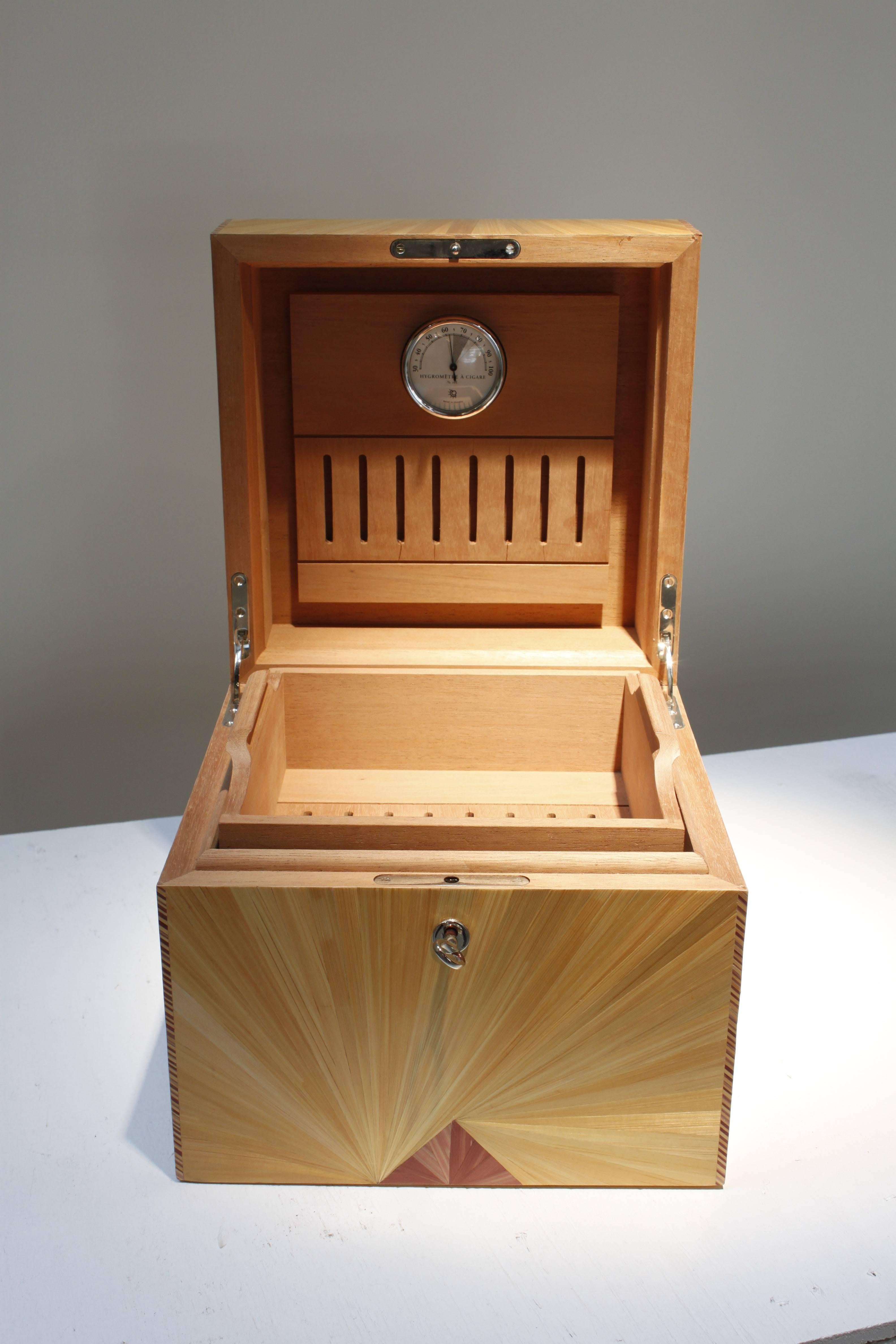 This cigar box, by Lison de Caunes, is done in straw marquetry. This item comes with the key and is lockable, with a built-in humidifier. This is part of the Marquis de Lafayette Collection.
