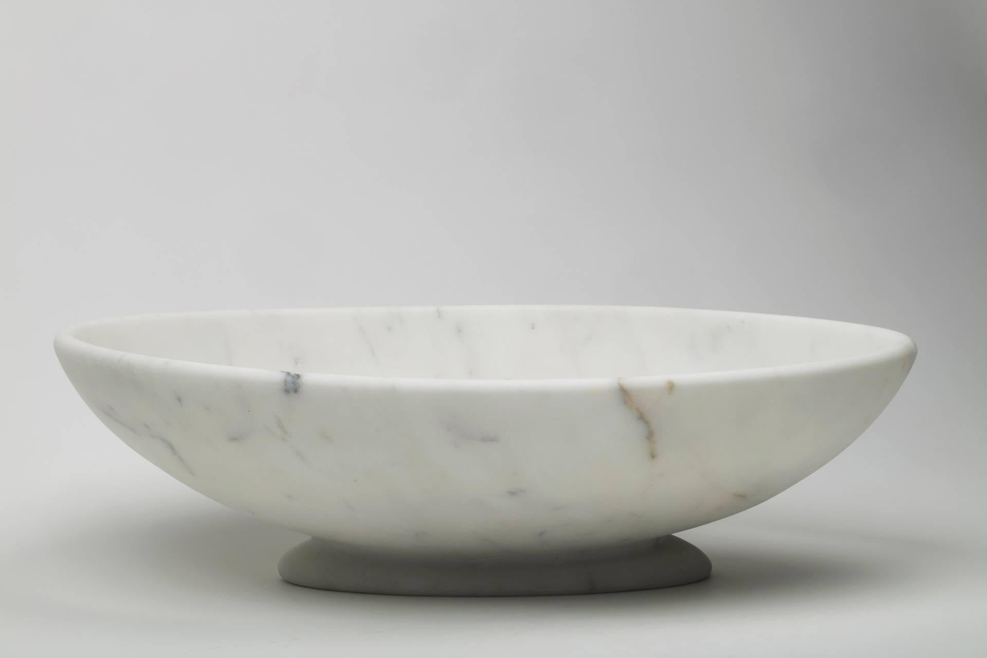 Big oval bowl in white Carrara marble. Each piece is in a way unique (since each marble block is different in veins and shades) and handmade by Italian artisans specialized over generations in processing the famous Carrara marble. Slight variations