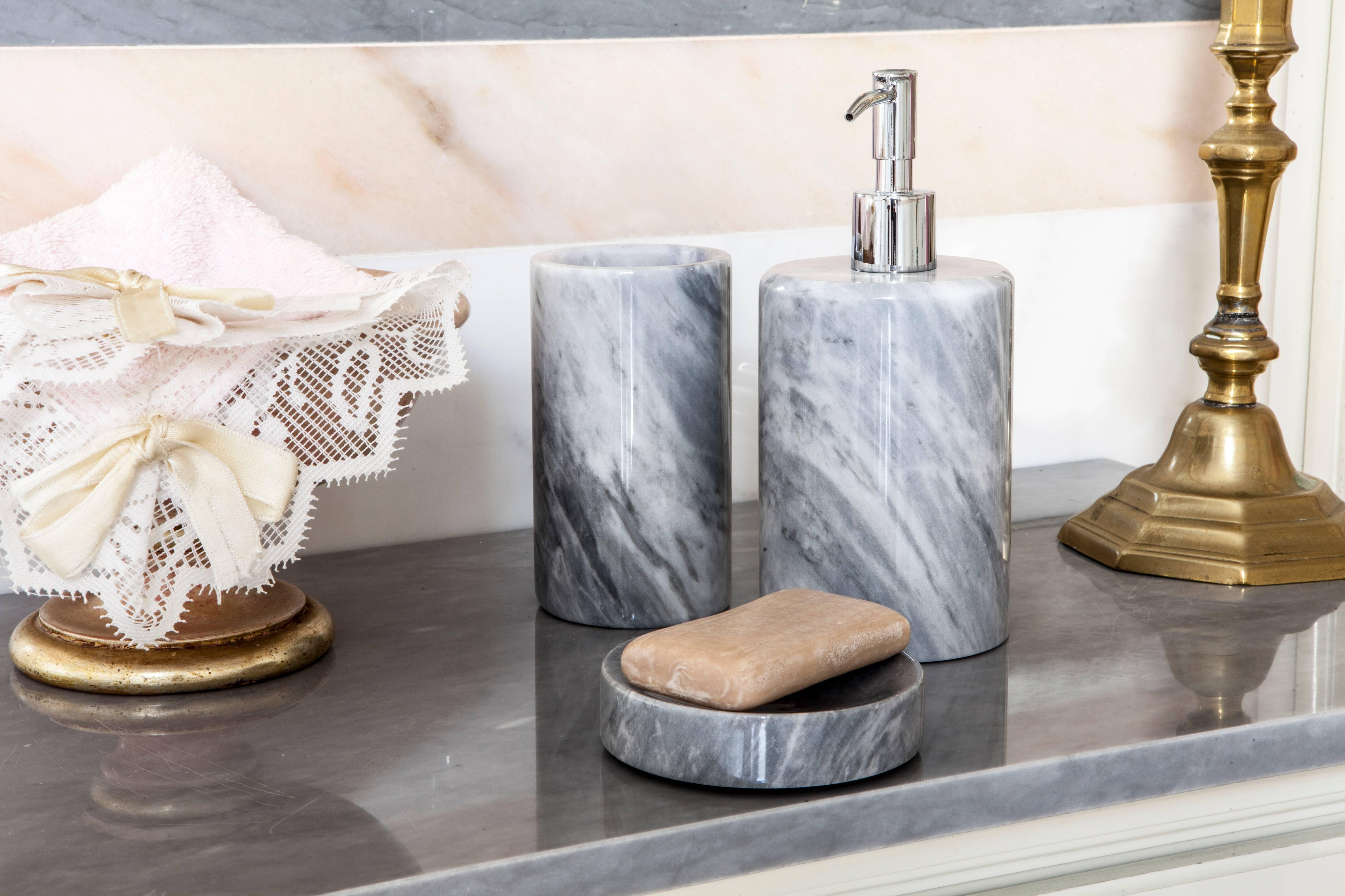 A rounded shape soap dispenser in grey Bardiglio marble.
Each piece is in a way unique (since each marble block is different in veins and shades) and handcrafted in Italy. Slight variations in shape, color and size are to be considered a guarantee
