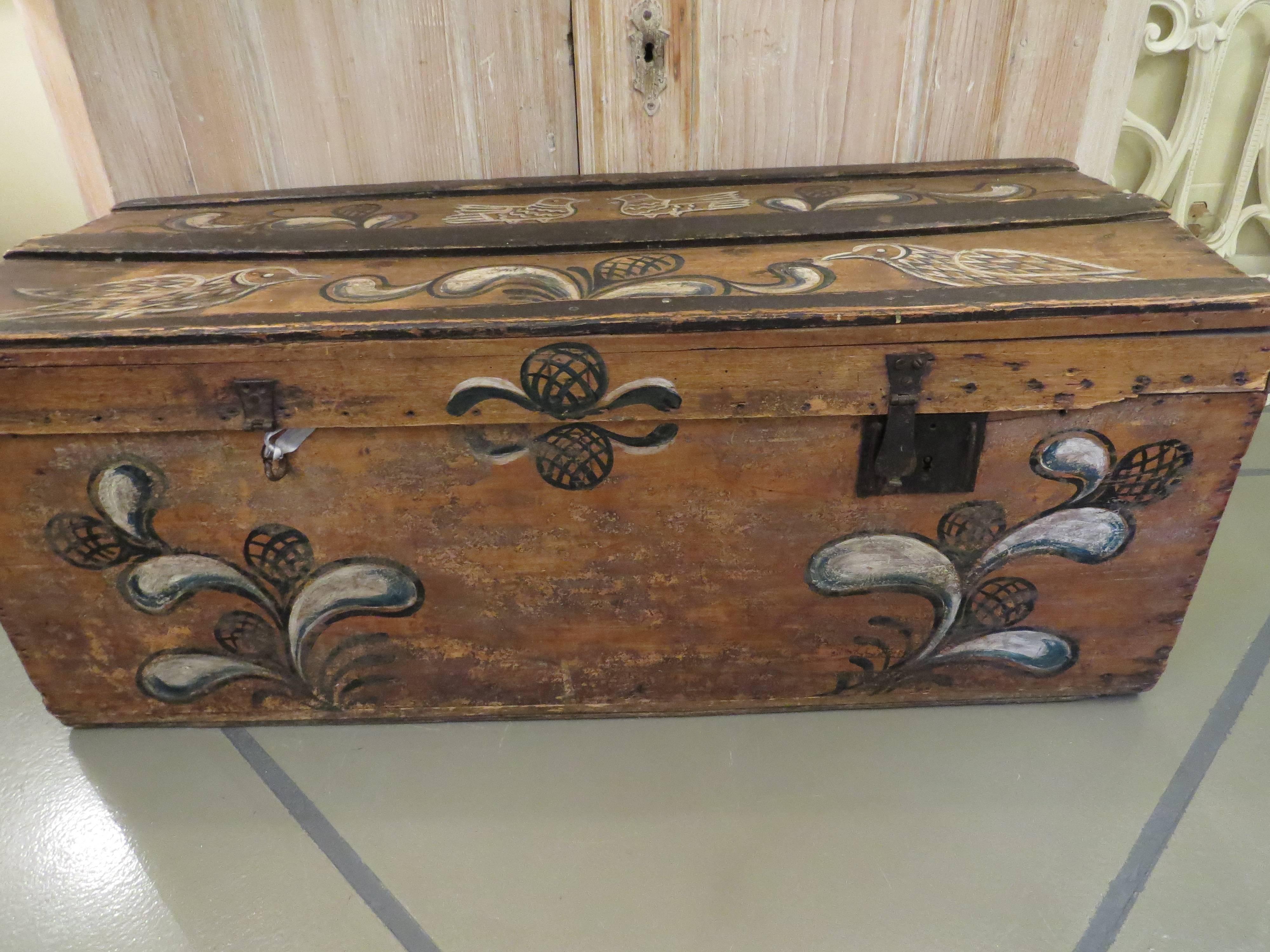 This Swedish trunk is painted with birds and flowers. It is made of wood with iron handles. It is from the 19th century.